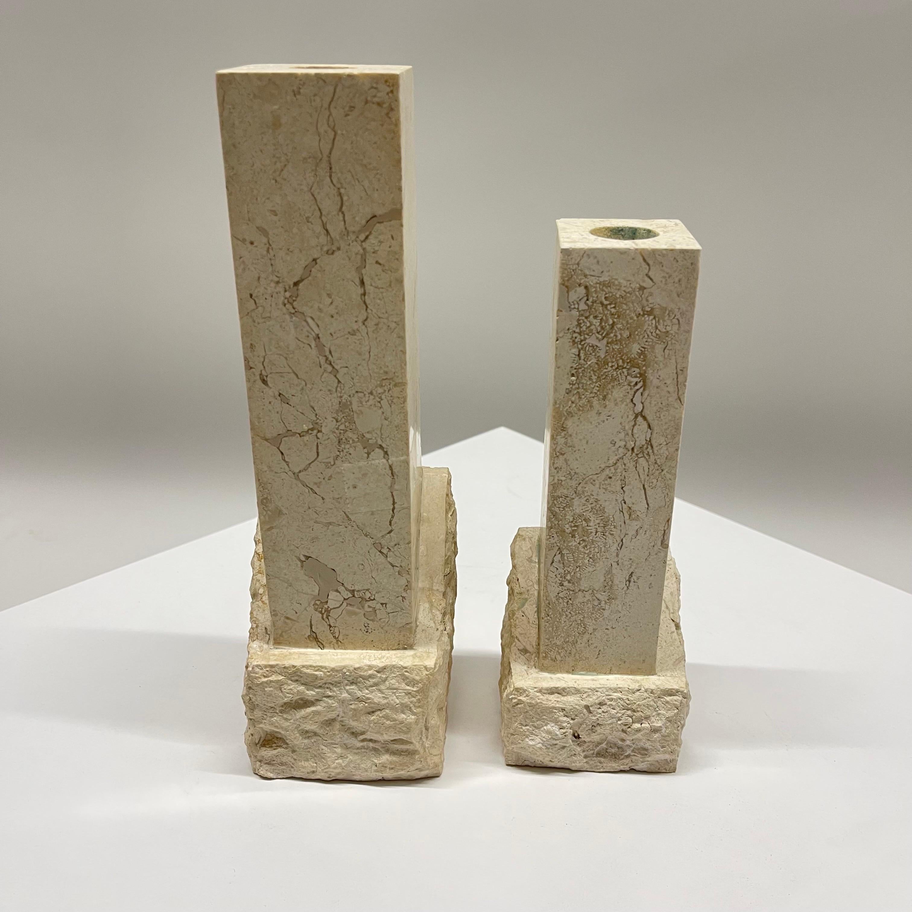 Exceptional asymmetrical pair of Post-Modern candlesticks or candle holders rendered in two textured tessellated travertine, both polished smooth as well as rough chiseled. Designed in Huntington Beach, CA and manufactured in the Philippines for