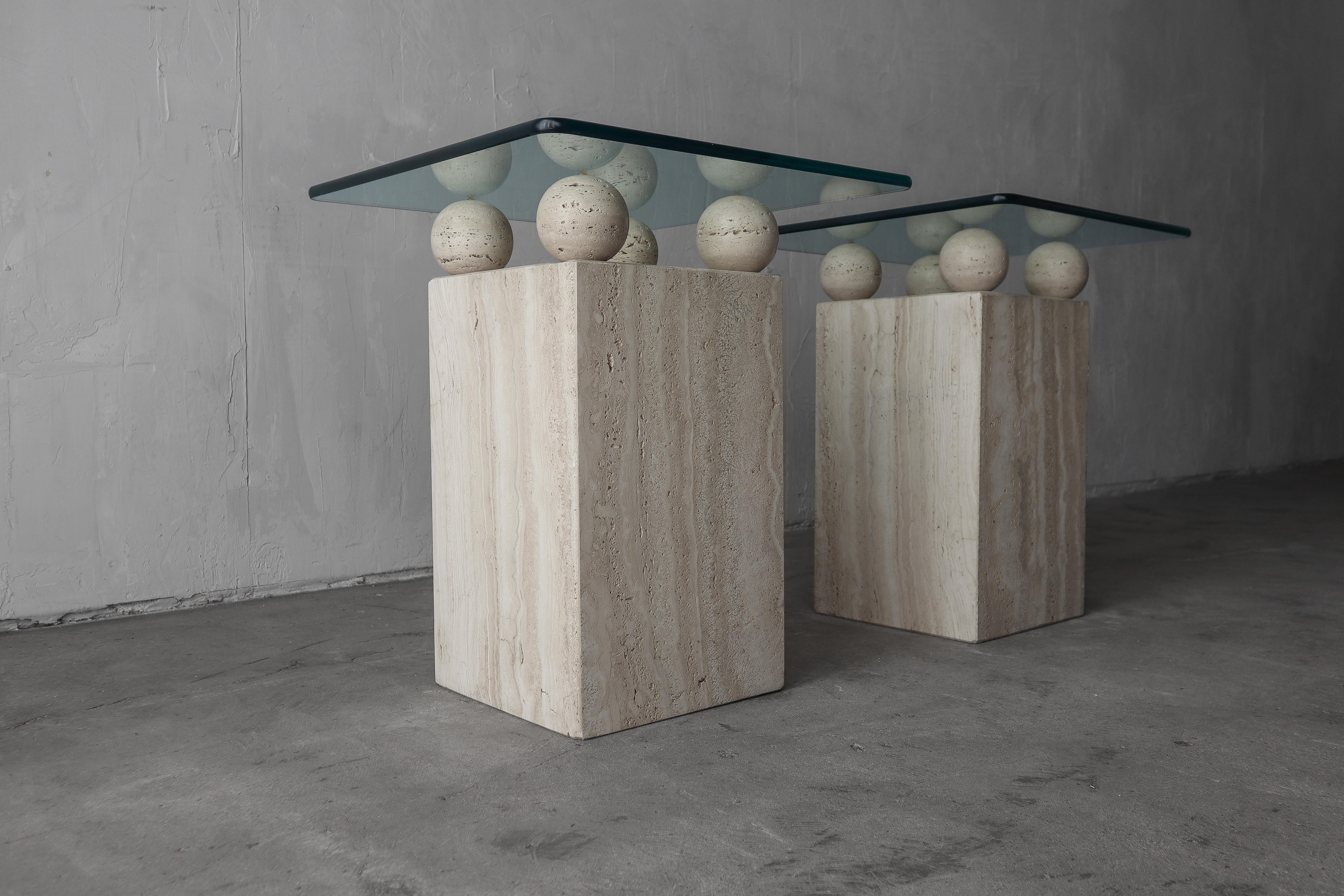Super rare pair of square travertine side table with gorgeous glass tops supported by unique solid travertine balls. Seen a lot of travertine tables but never a pair like this.

Bases measure 11