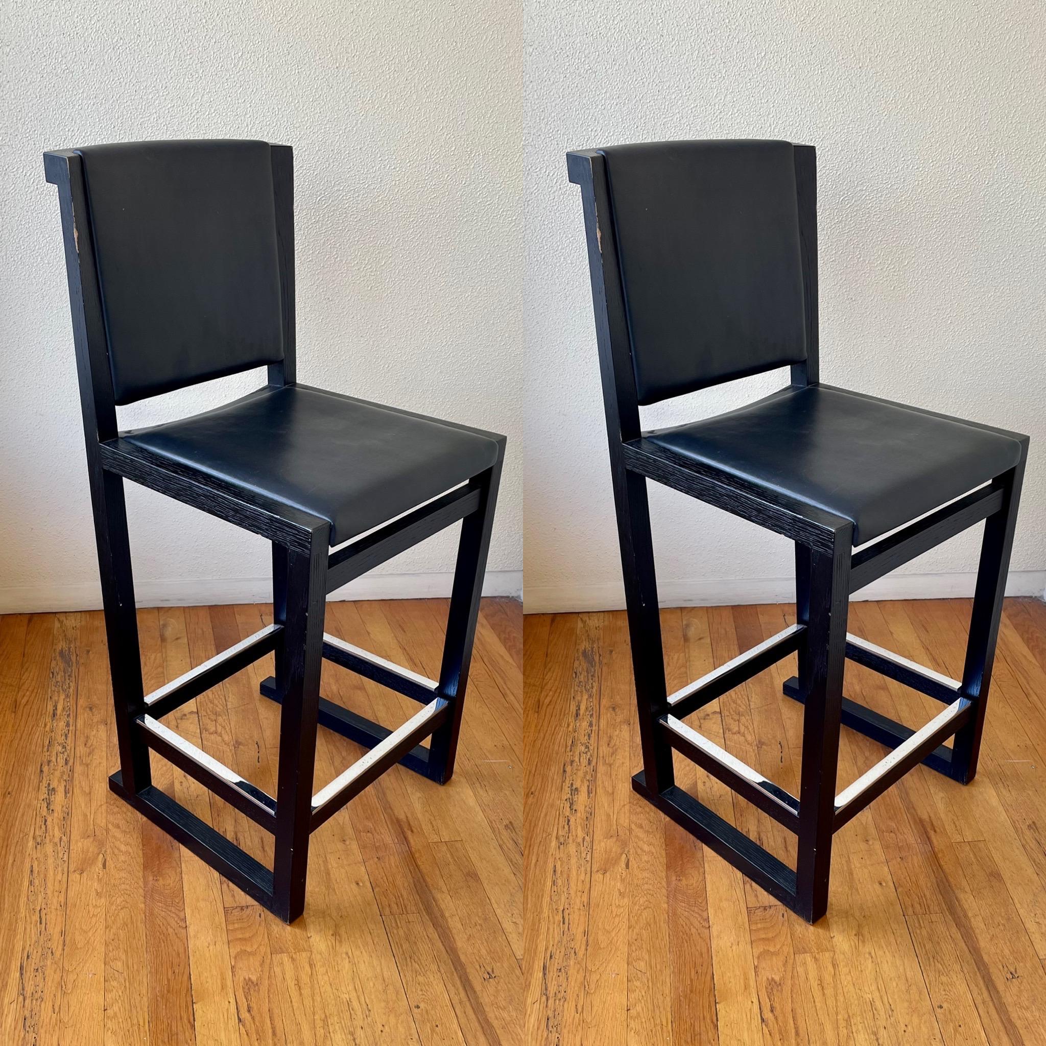Great pair of solid oak ebonized frames barstools with leather seat and back and chrome footrest we have polished and cleaned the chrome to our best buts show wear and pitting due to age.