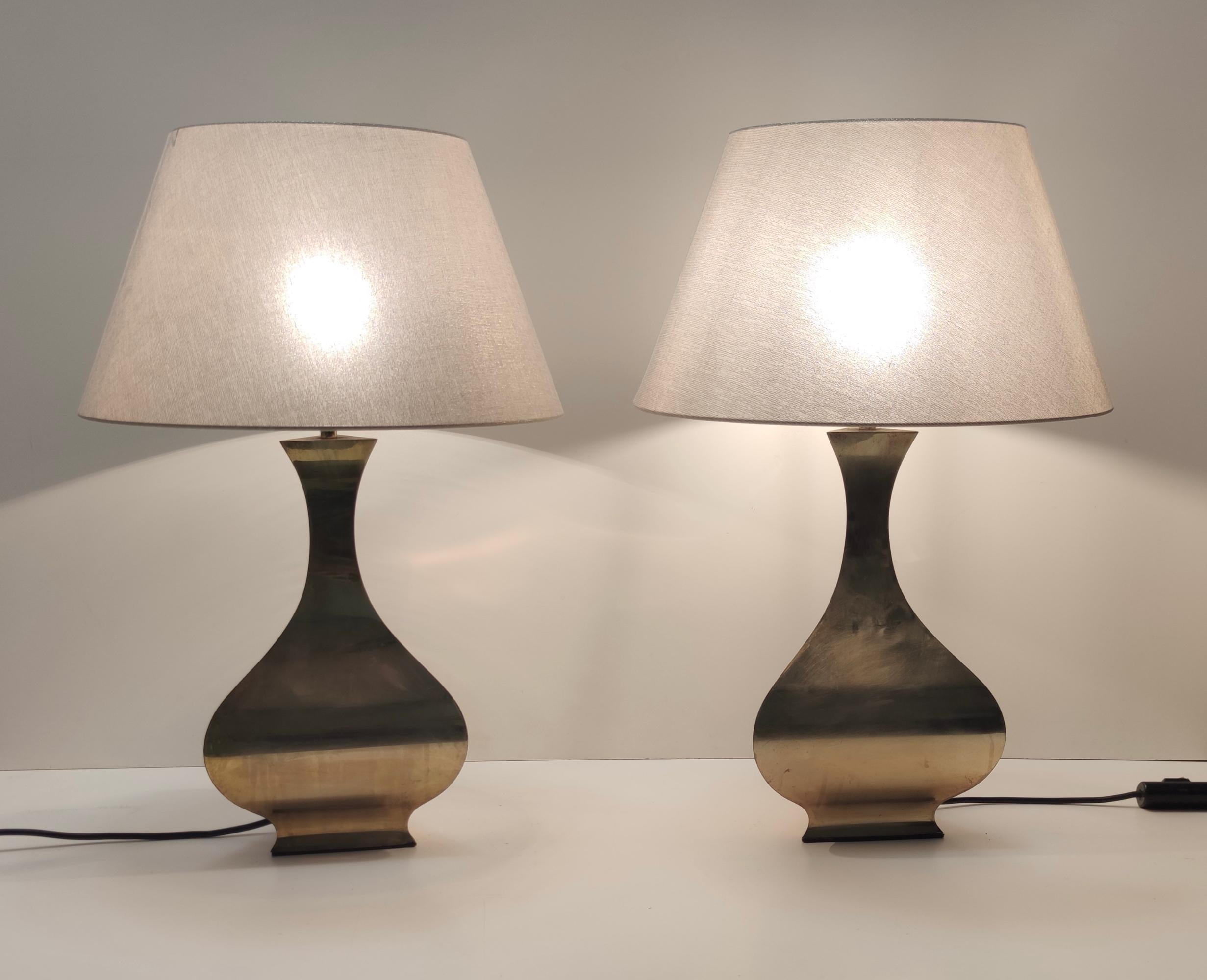 Made in Italy. 
Tonello and Montagna Grillo designed these table lamps in 1970s - 1980s
Their base is in brass and their newly-changed lampshades are in fabric, which has golden threads.
These lamps are vintage, therefore they might show slight