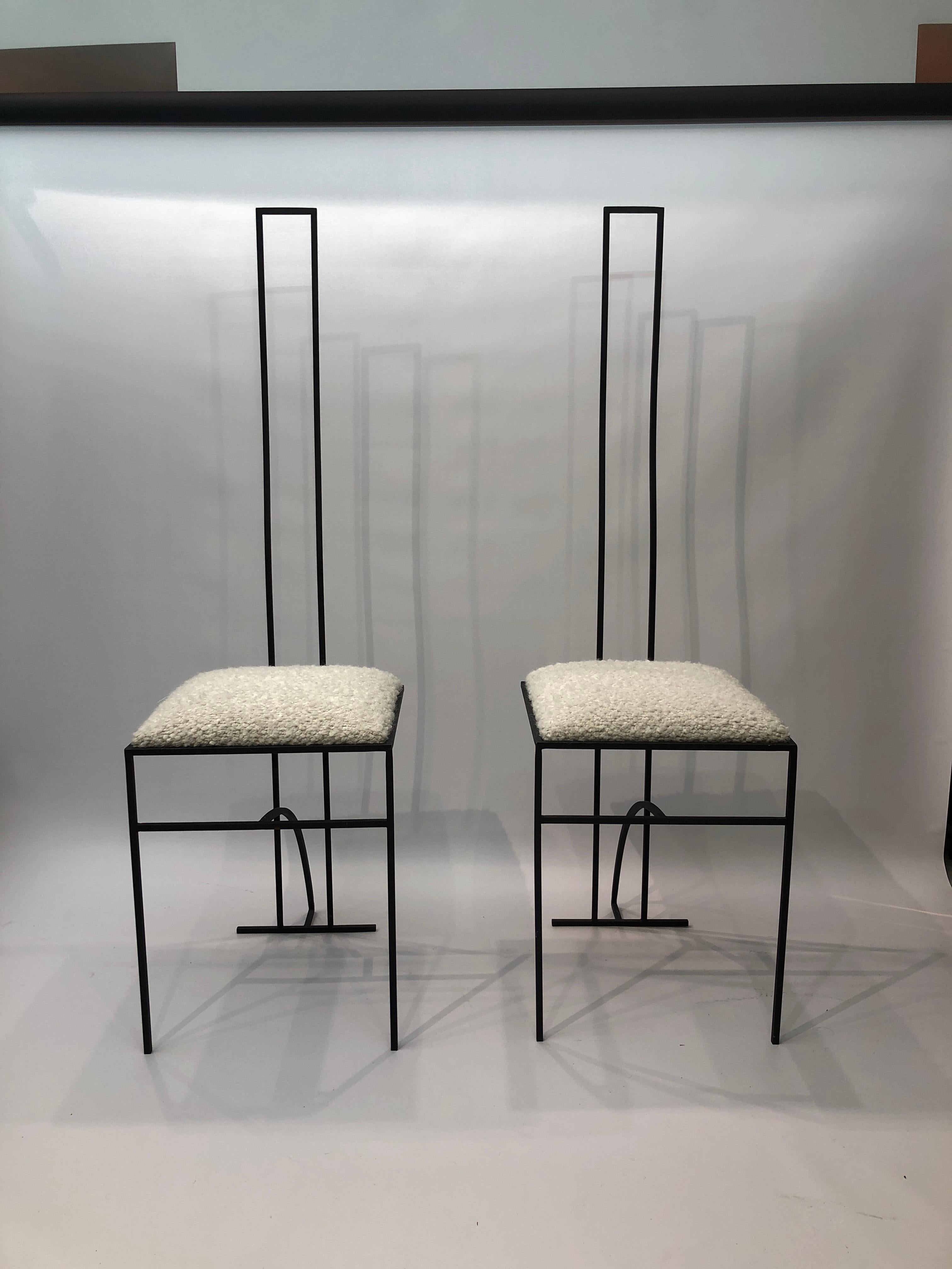 Pair of strictly minimal chairs from the 1980s with boucle seat upholstery giving a contrast of materials and texture making them more inviting with its fluffy feel. Simple geometric line with square seat.
The boucle upholstery fabric is from