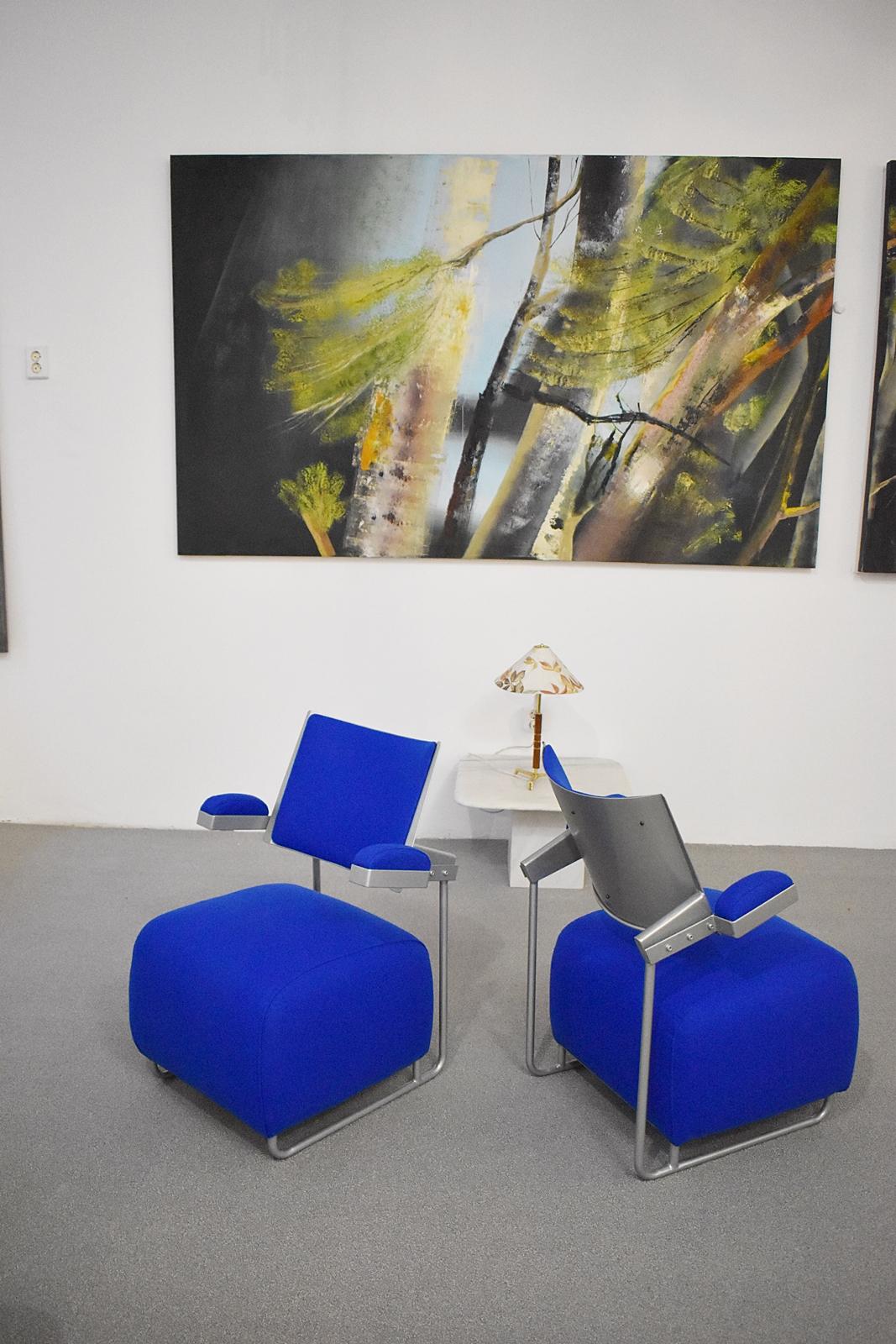 Stunning set of two freeform easy armchairs in strong blue upholstery.
The chair consists of a tabouret seating with armrests and curved back. The metal armrests run over into the chairs sled-legs.
In restored, reupholstered condition.