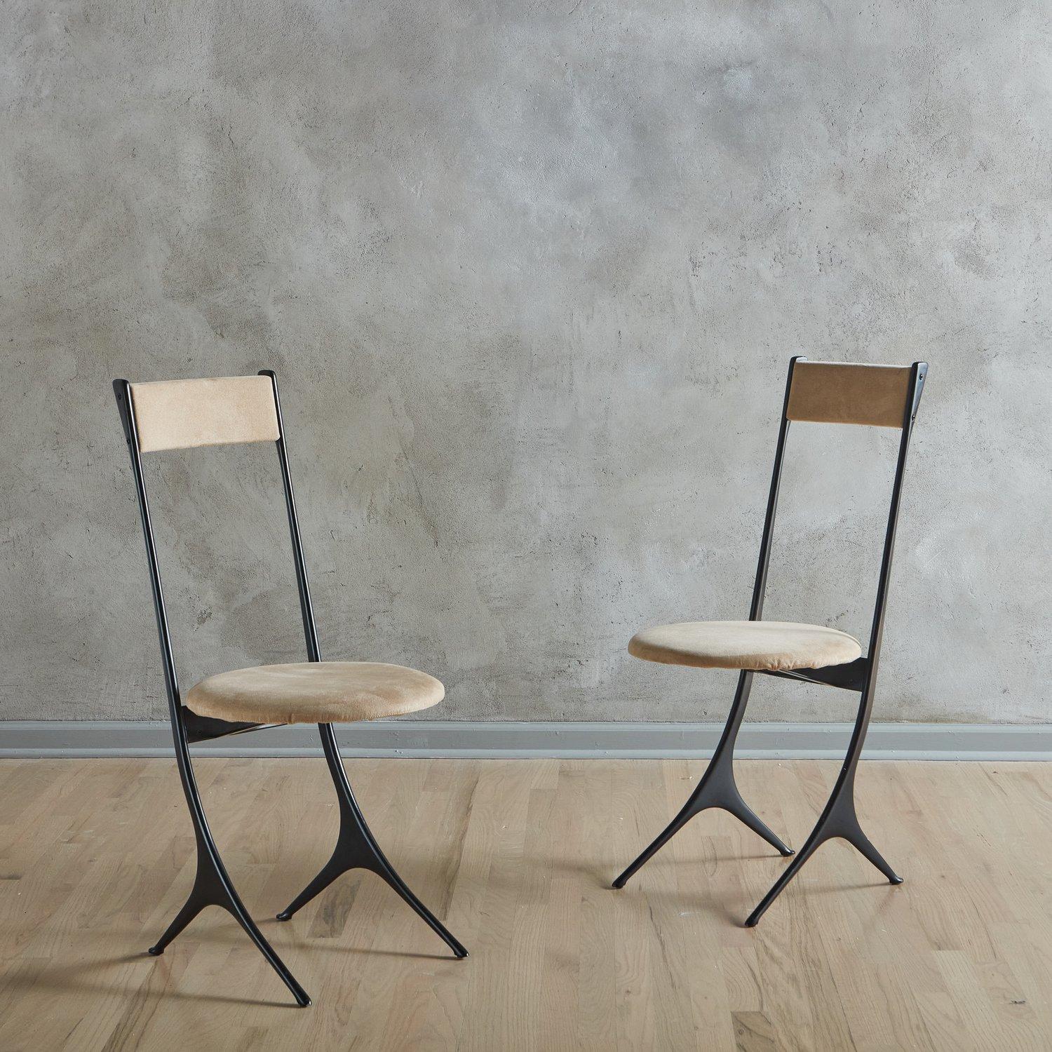 A pair of Italian post modern dining chairs produced by Zanotta in the 1980s. These chairs feature sculptural black aluminum frames with circular seats and rectangular seat backs, which retain their original taupe vegan suede upholstery. Marked