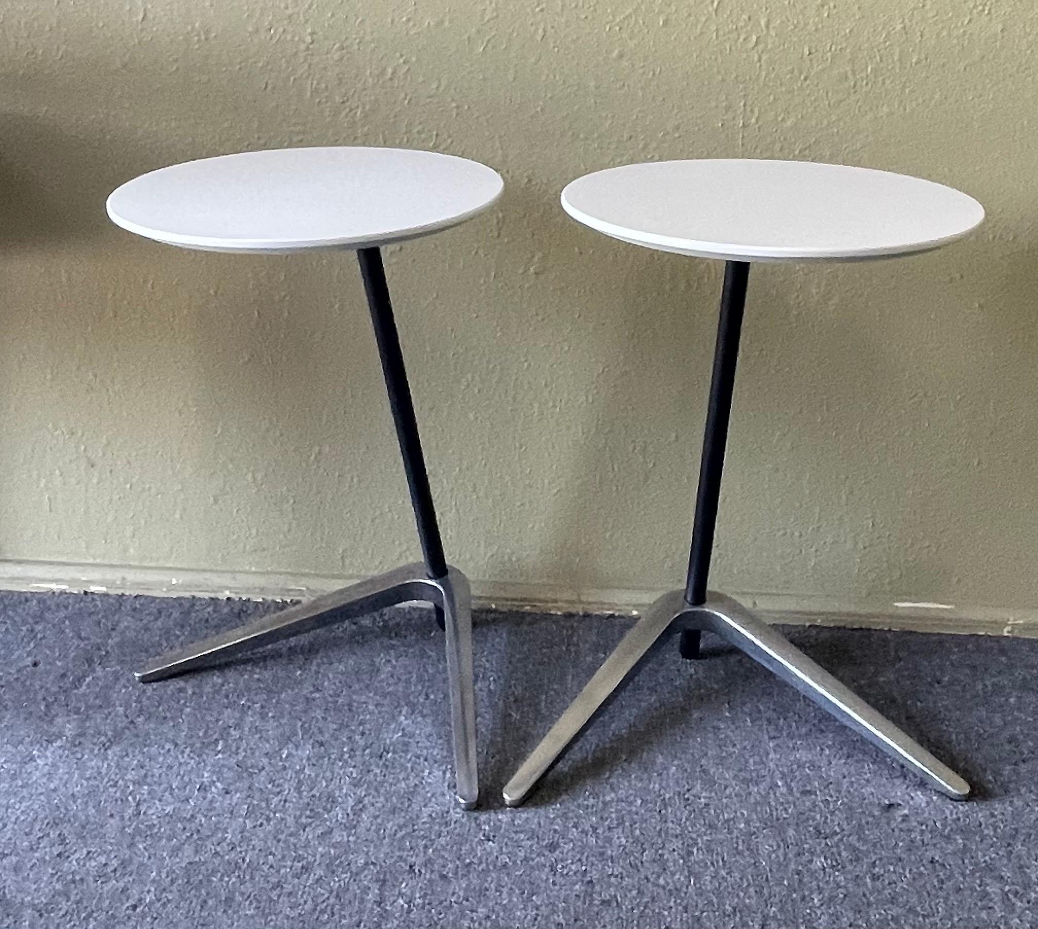 Pair of Postmodern side tables with round white laminate tops and angled aluminum boomerang shaped bases, circa 1980s. The table tops are 15.75