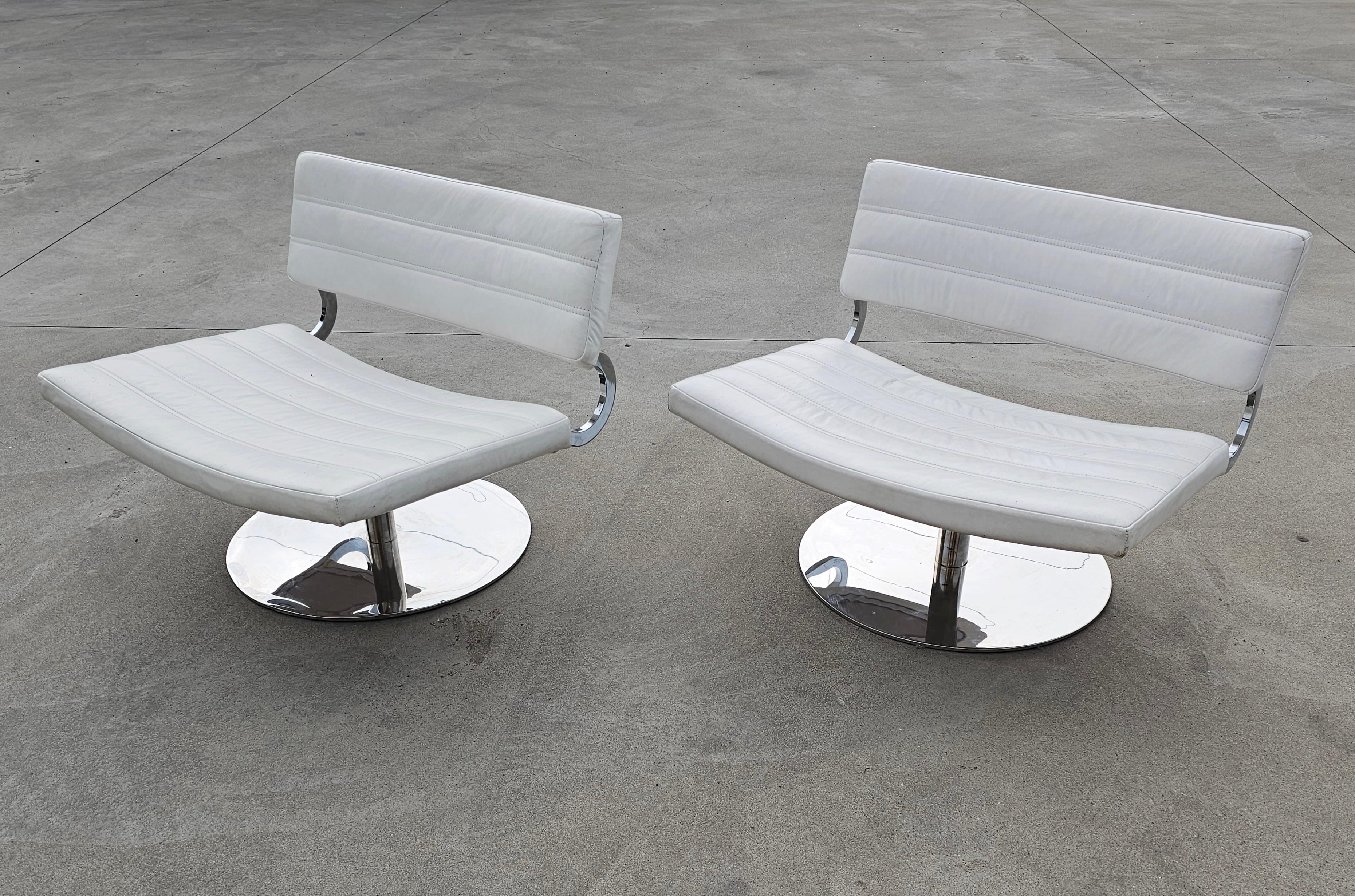 Dans cette liste, vous trouverez des chaises longues pivotantes de style moderne du milieu du siècle ou postmoderne. Ils sont dotés d'une lourde mais élégante base ronde en acier inoxydable et d'une assise et d'un dossier en cuir blanc. Fabriqué en