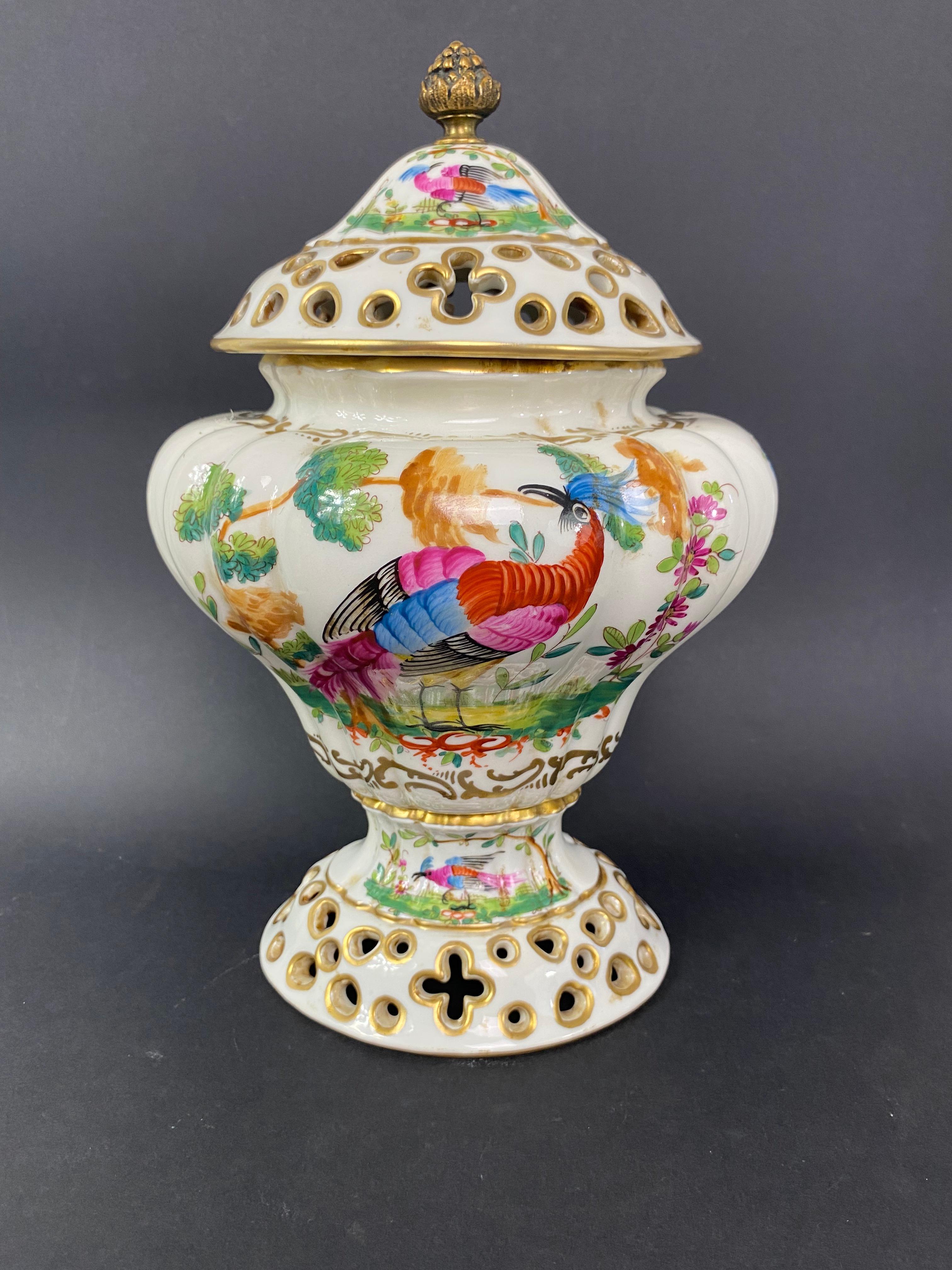 Very pretty pair of baluster shaped porcelain pot pourri vases with gadroons on pedestal,
decorated with birds, pheasants, in polychrome and gold landscapes. Wonderful, very colorful decor.
The lids and feet are perforated to let in the aromas of
