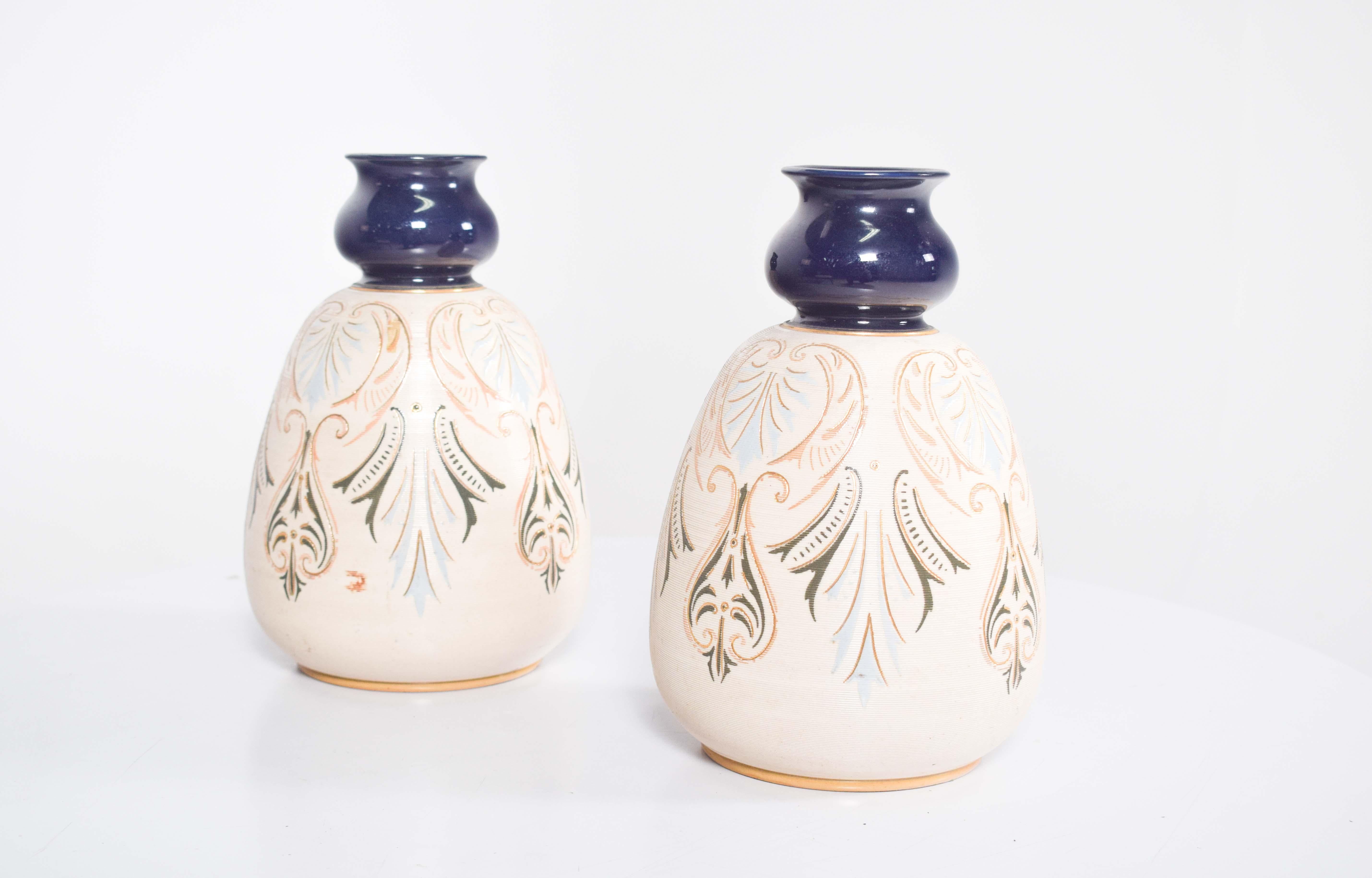 Cette élégante paire de vases en poterie de couleur crème dégage un charme à la fois rustique et raffiné, parfait pour rehausser les intérieurs traditionnels ou éclectiques. Les vases se distinguent par leur forme bombée qui s'affine vers le haut