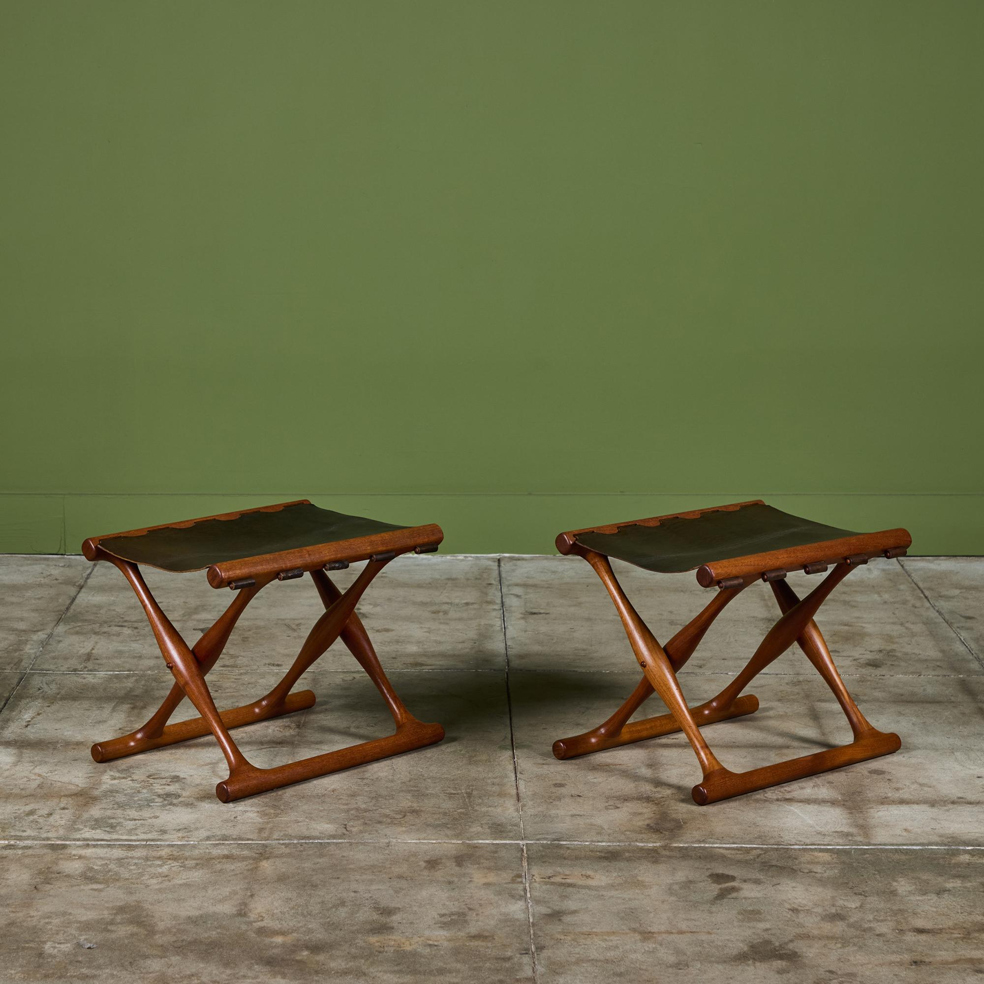 Pair of leather folding stools designed by Poul Hundevad for Vamdrup Stolefabrik, c.1950s, Denmark. The stools feature a solid teak frame and brown leather sling seat secured by wooden dowels. The stools can easily be folded for storage or easy