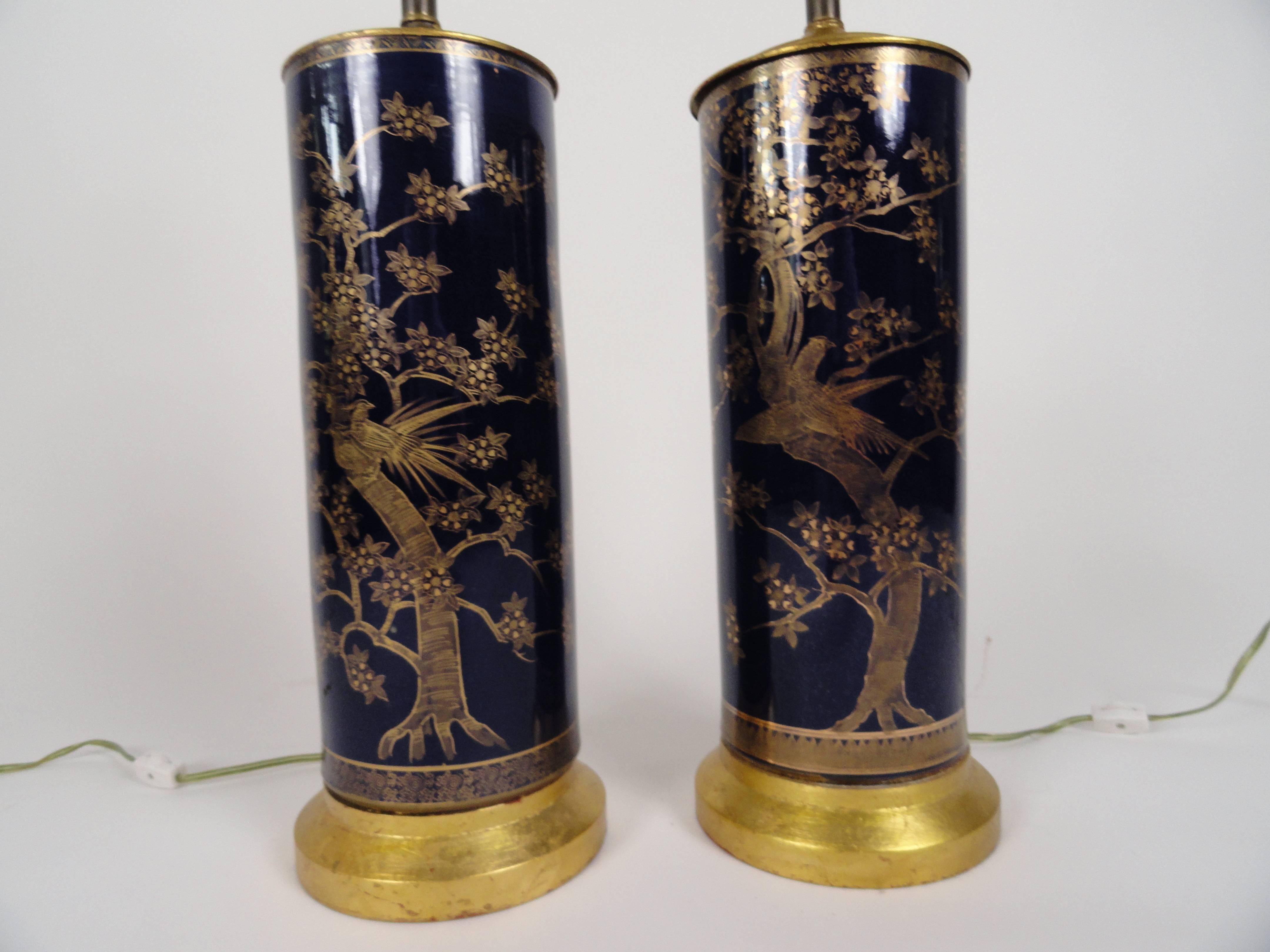Pair of powder blue porcelain lamps with hand-painted gilt decoration of birds and blooming flowered branches. Highly glazed. Gold leaf wood bases. Rewired with inline switch.