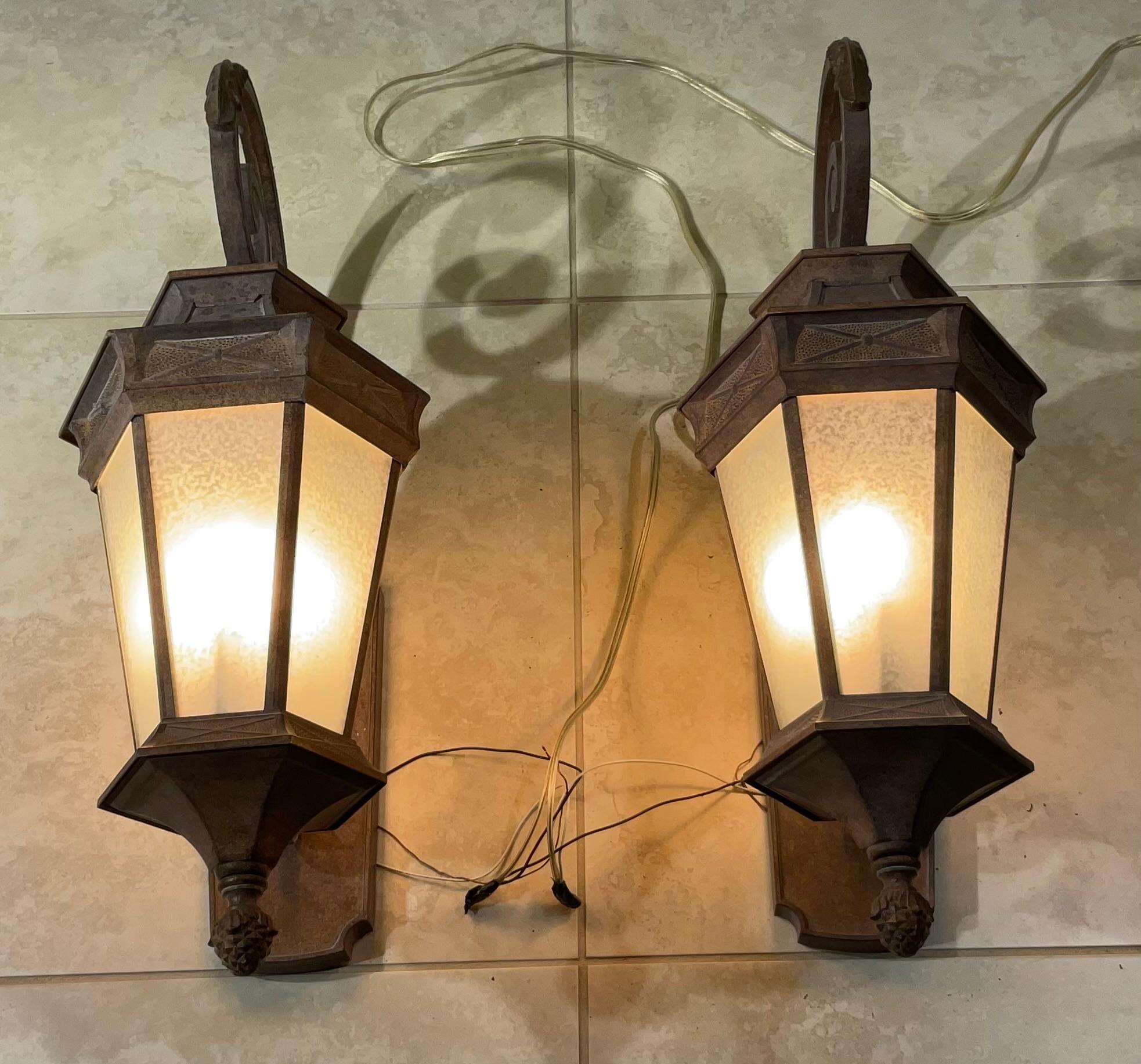An elegant outdoor pair of lighting  in the neoclassic style into a contemporary structure ,made of power coated aluminium, decorative acrylic glass like sides , ample light exposure of three  60/watt lights  ,great detailed craftsmanship . 
Up to