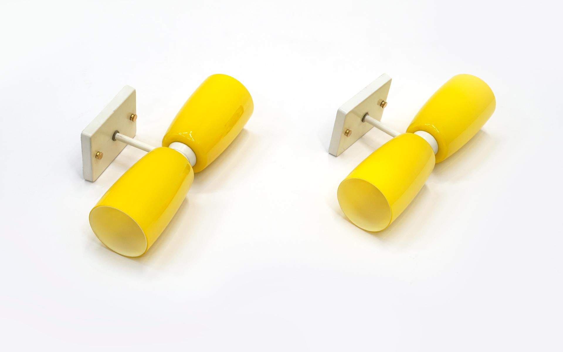 Two 1960s Prescolite wall sconces in yellow glass and white fixture. Original with no scratches or chips to the glass. A rare opportunity to own a pair in such pristine condition.