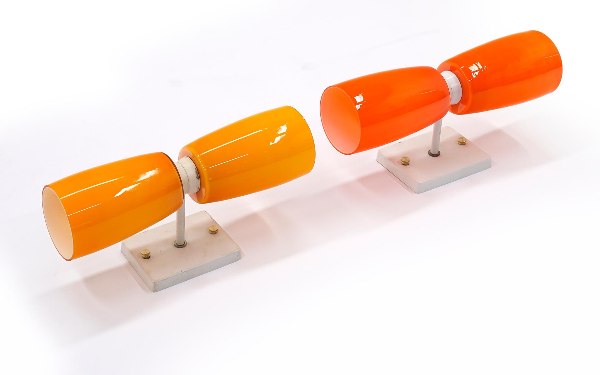 Due appliques Prescolite degli anni '60 in tre colori di vetro arancione con finiture bianche. Originale, senza graffi o scheggiature sul vetro. Una rara opportunità di possedere una coppia in condizioni così incontaminate.