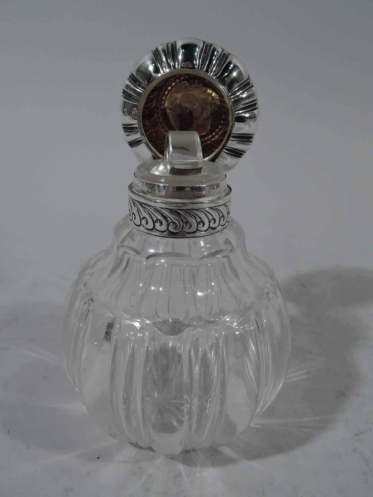 Pair of Victorian perfumes. Made by Grinsell & Sons in London in 1892. Each clear glass globular bottle with alternating flutes and lobes and faceted shoulders. Sterling silver collar and hinged bun cover. Cover has central frame with interlaced