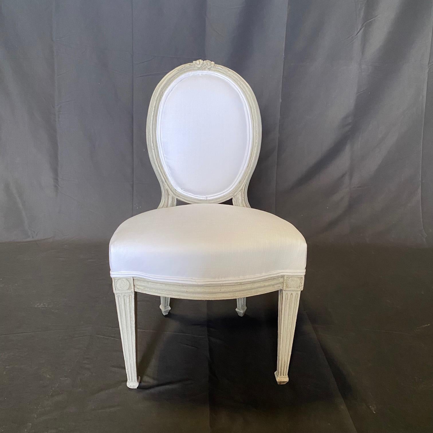 Queste poltroncine francesi Luigi XVI dipinte di bianco, di qualità museale, potrebbero risalire al 1700, con una splendida patina sulla vernice originale, e sono state recentemente tappezzate con un nuovo tessuto in misto lino di alta gamma, ma il