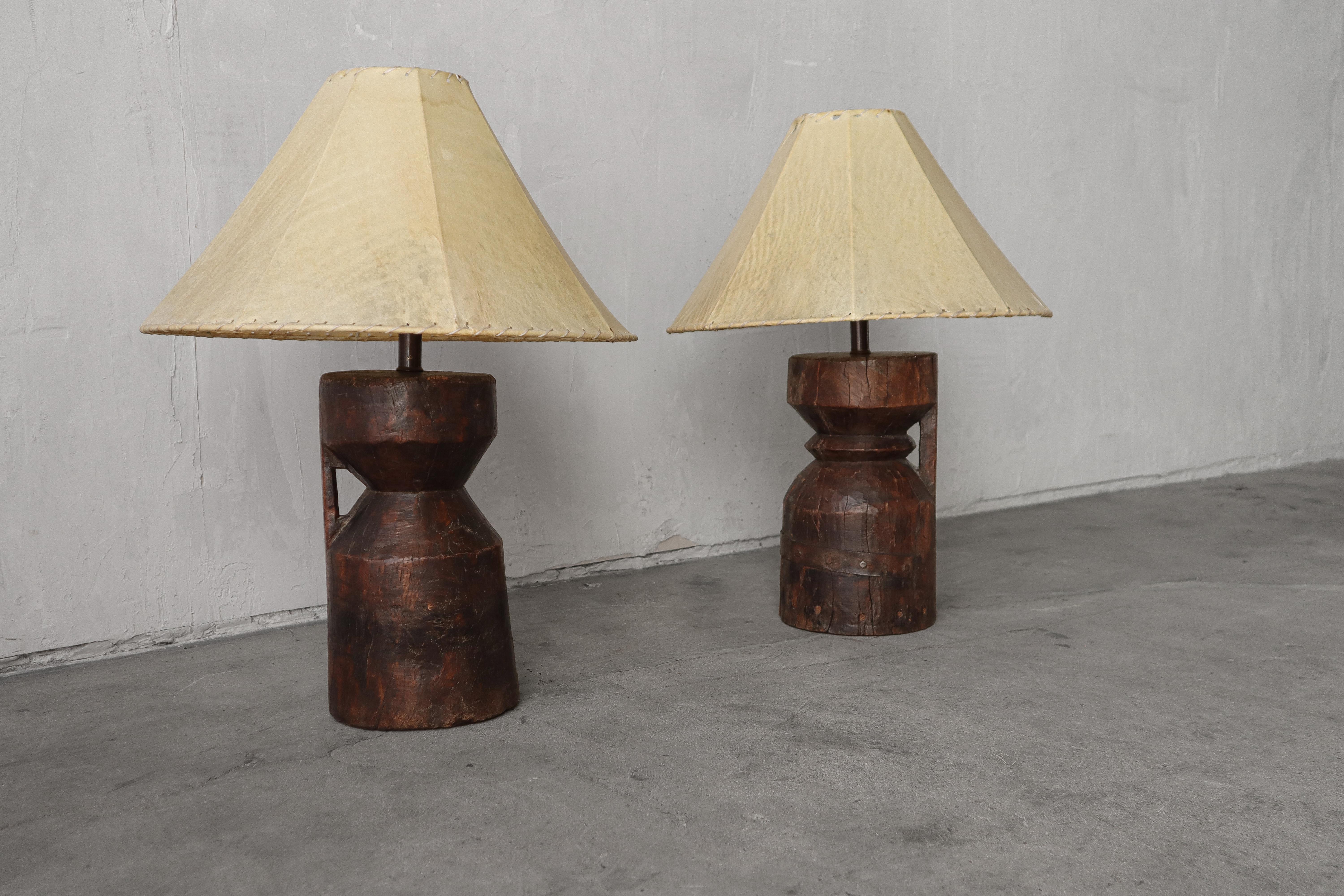 Chunky pair of antique African artifact lamps.  Carved from solid wood.  Each one is a bit different than the other, adding to their uniqueness and character.  These lamps are the perfect addition to almost any space, especially one that is wabi