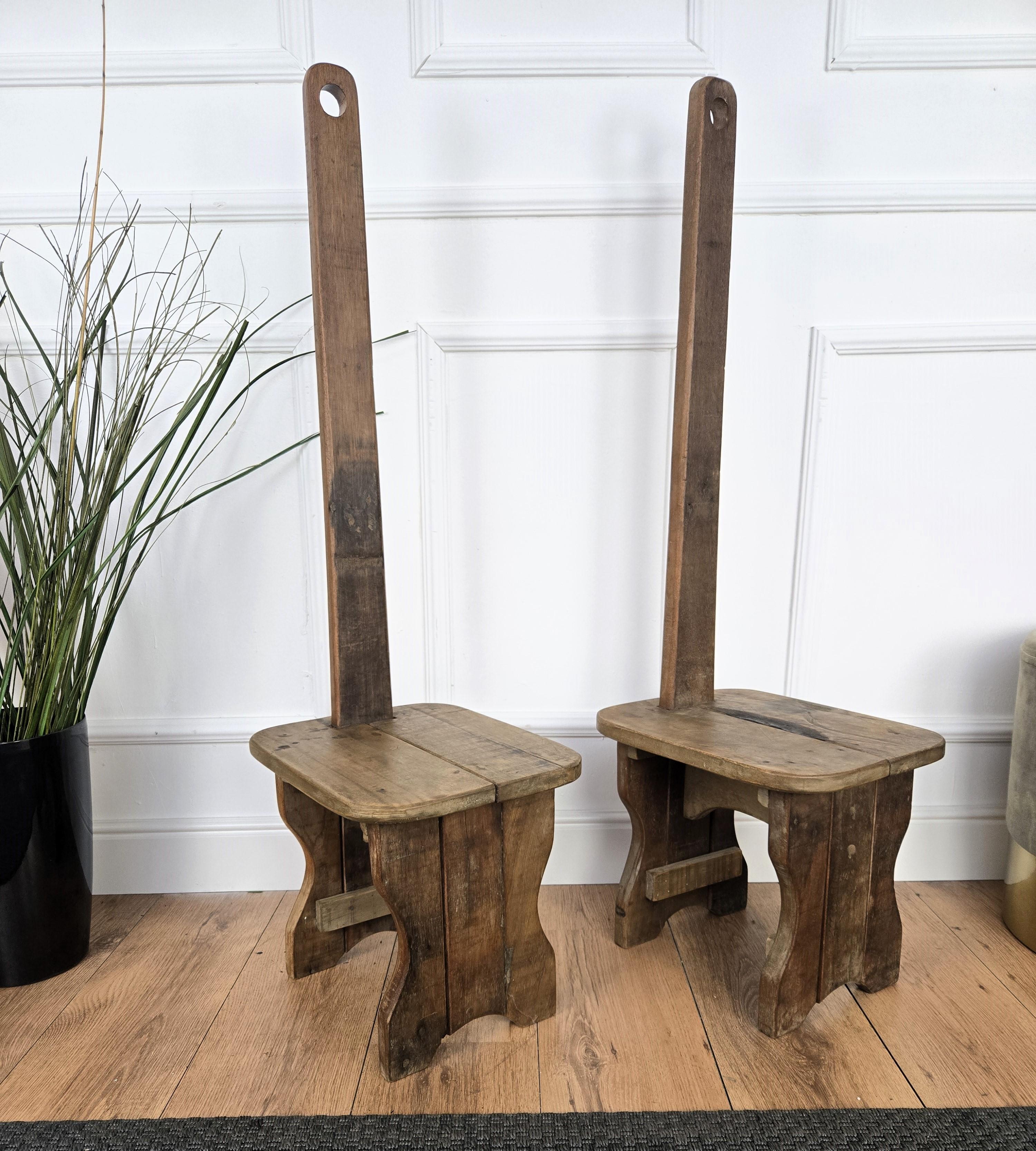 Beautiful pair of Italian rustic country wooden chairs, stools or benches, with the characteristic backrest and typical legs in original aged natural color giving the rich and beautiful patina that makes it look wonderful in every interior. 

The