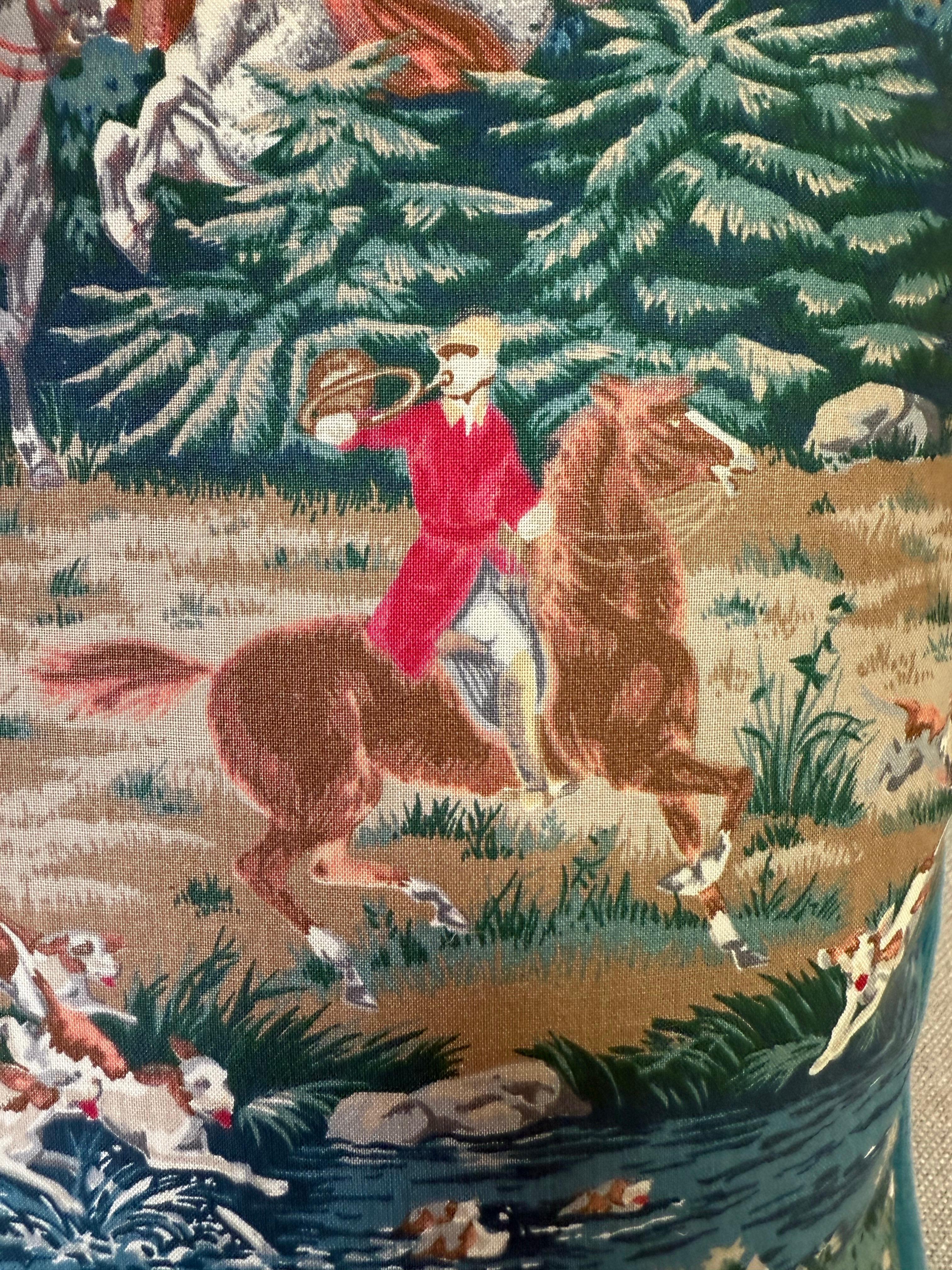 Questi cuscini imbottiti di piuma presentano un tessuto con scene di caccia in stile vintage. Il design mostra un'elaborata e dettagliata scena di caccia alla volpe con cavalieri a cavallo vestiti con i tradizionali cappotti da caccia rossi, un