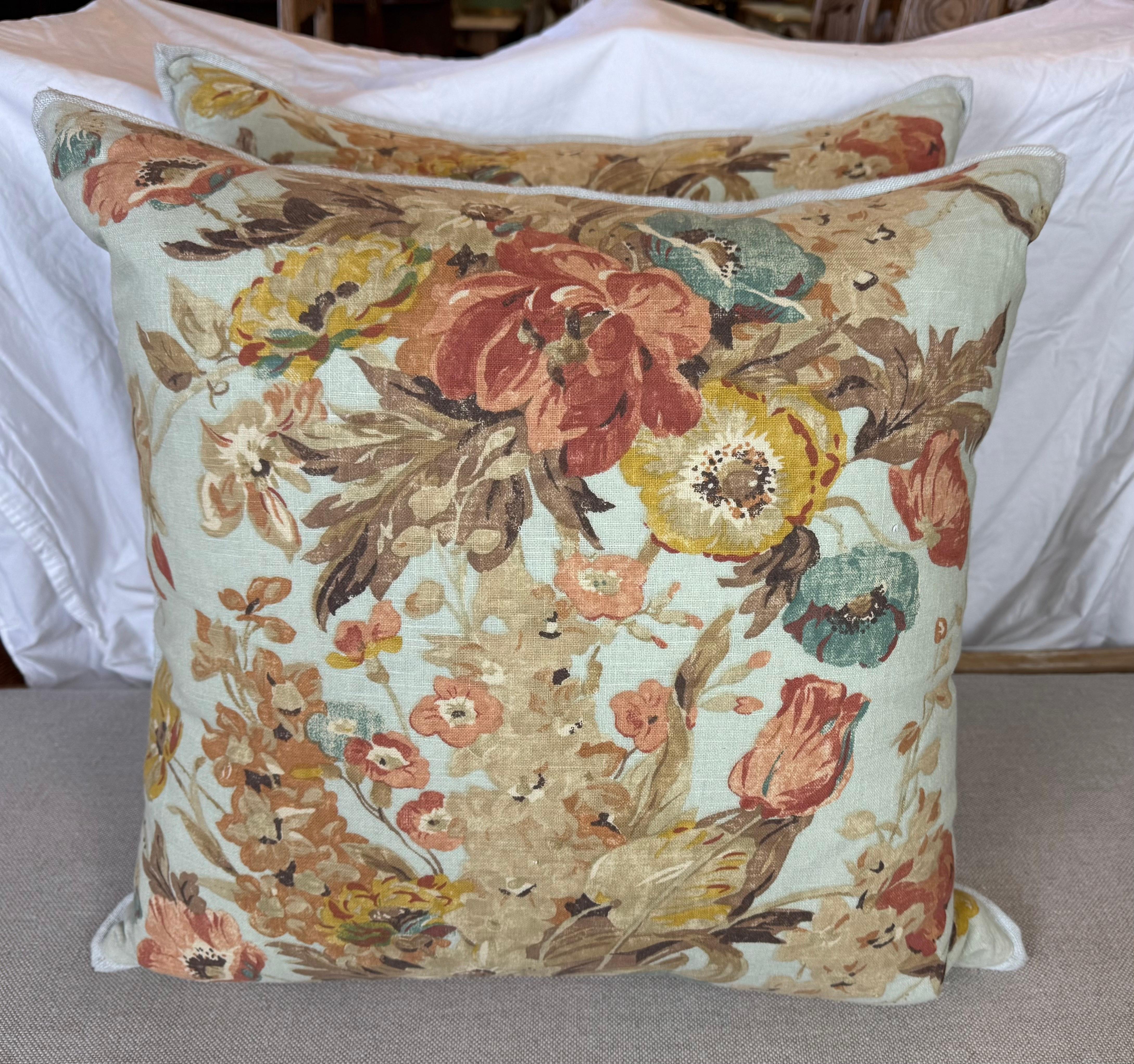 Ces coussins décoratifs présentent un design floral d'inspiration vintage sur un fond doux et atténué. Le motif complexe présente un mélange de fleurs dans des tons chauds de rouge, jaune, beige et brun, complétés par des touches de bleu et de vert,