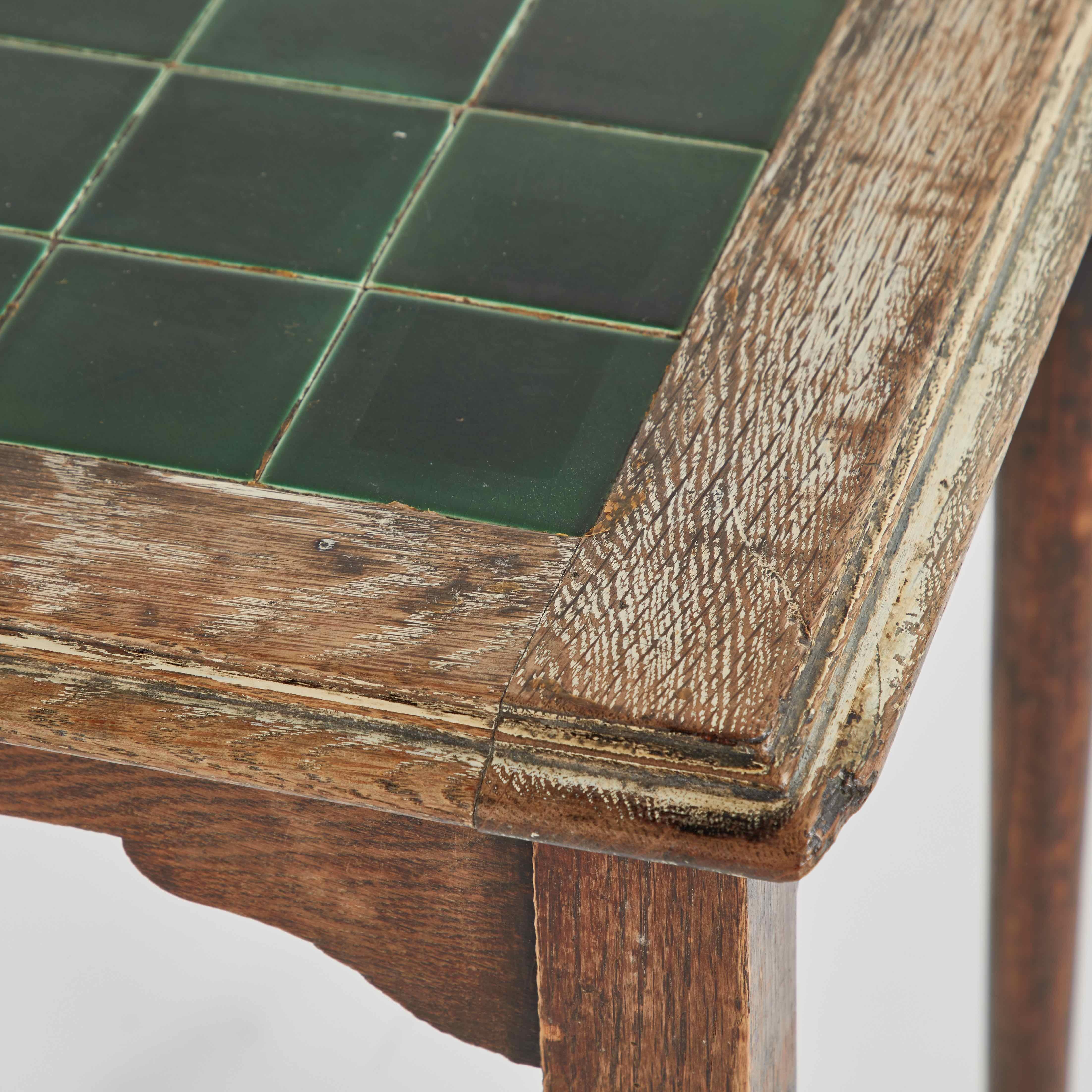 A pair of  green tile topped pub tables.