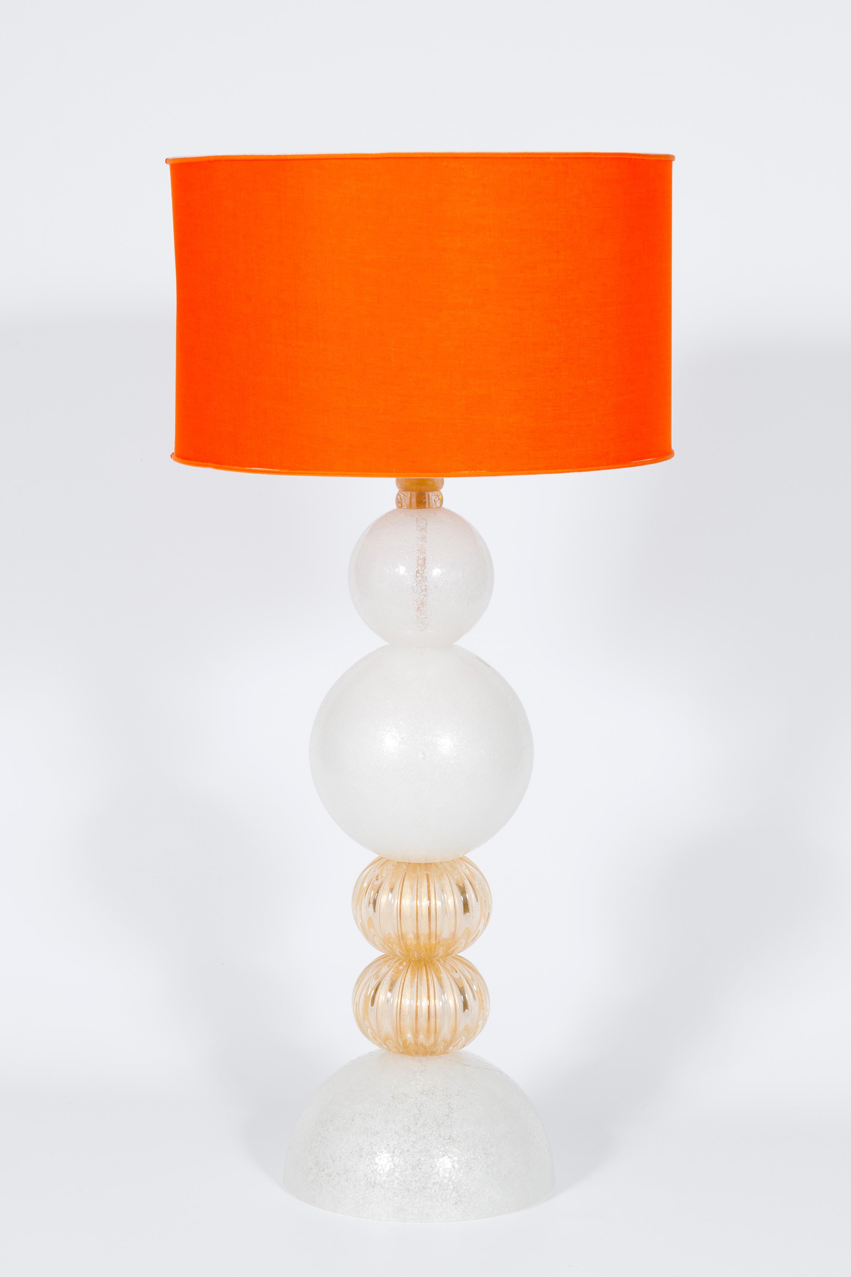 Pair of Pulegoso Murano Glass Table Lamps with 24-carat gold, 1990s, Italy.
This refined pair of Italian table lamps is a unique and precious piece of art. 
At its base, a white semi-spheric glass element sustains the lamp stem, made of two