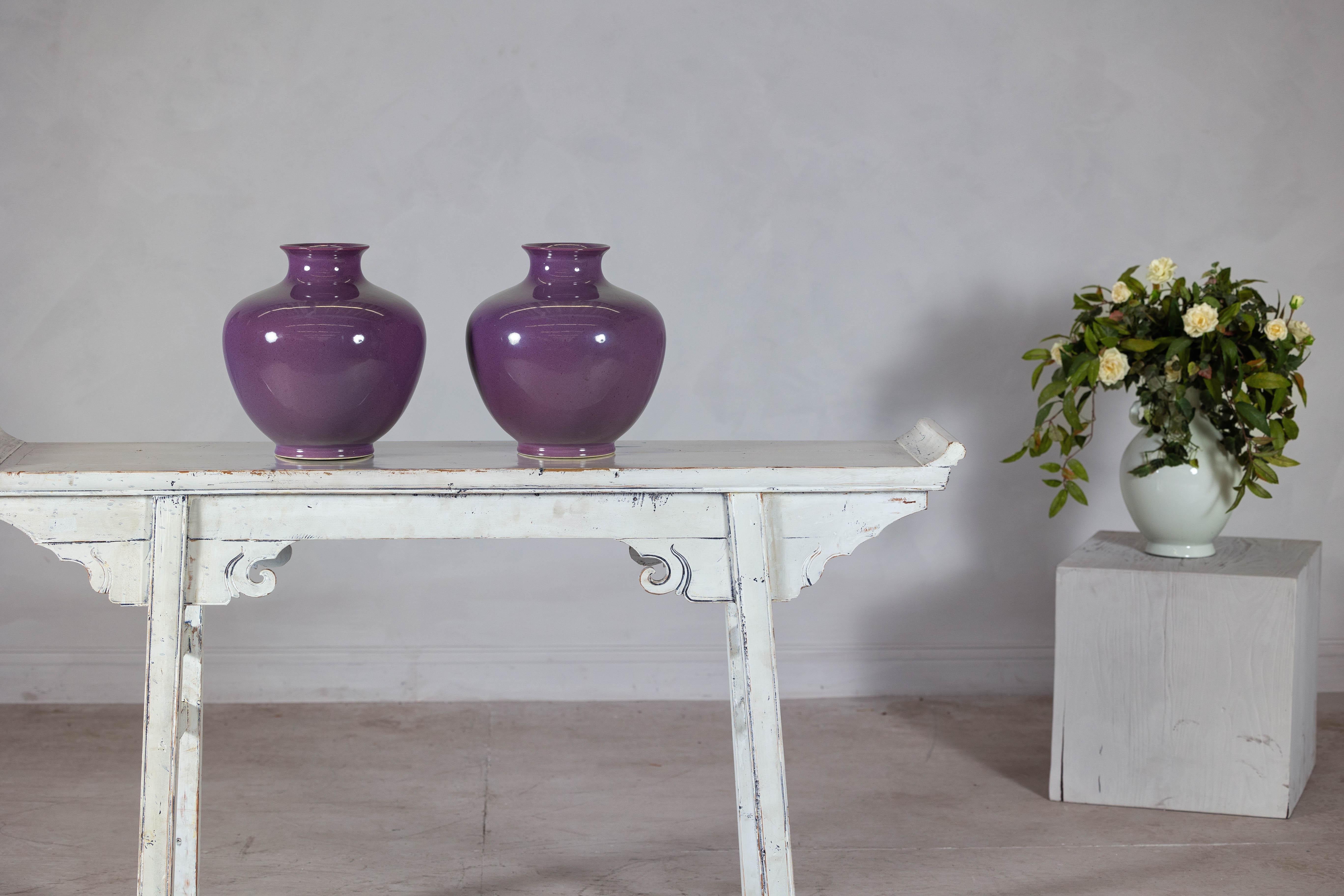 Este exquisito par de jarrones de cerámica morada combina la elegancia atemporal con el encanto contemporáneo. Sus vientres redondeados y una abertura de 10 cm de diámetro perfectamente proporcionada crean una silueta equilibrada, ideal para realzar
