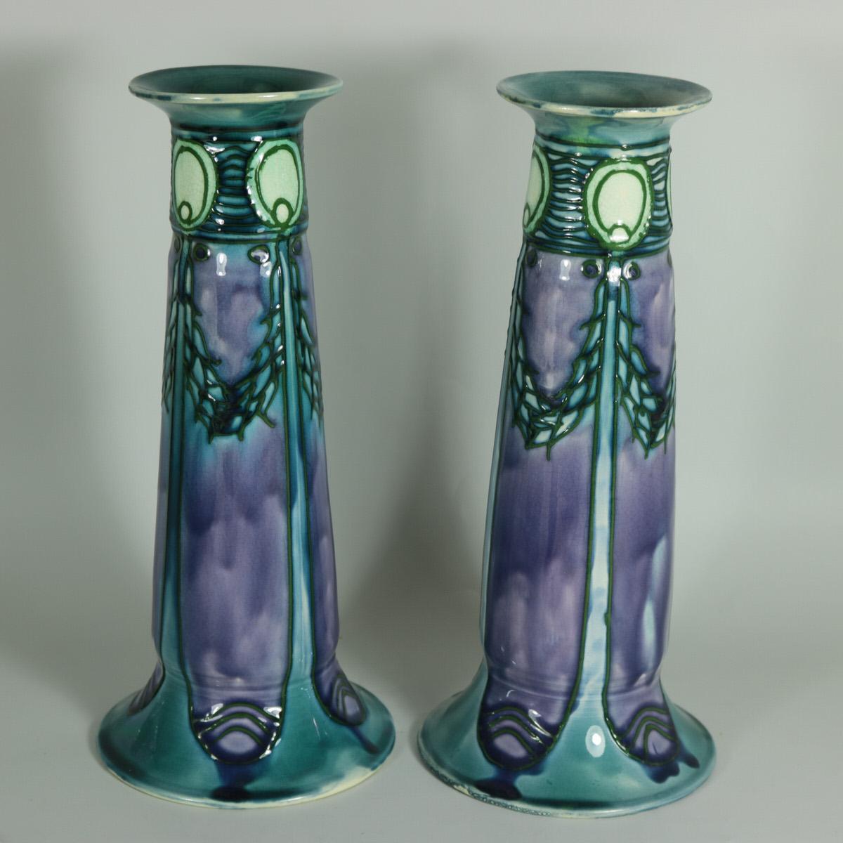 Pair of Minton Secessionist No.1 vases with purple, blue and white slip-trailed decoration. Art nouveau stylised patterns. Dark green tube lined outlines. Cream interior and base. Maker's marks including printed 'MINTONS LTD NO.1' to bases, also