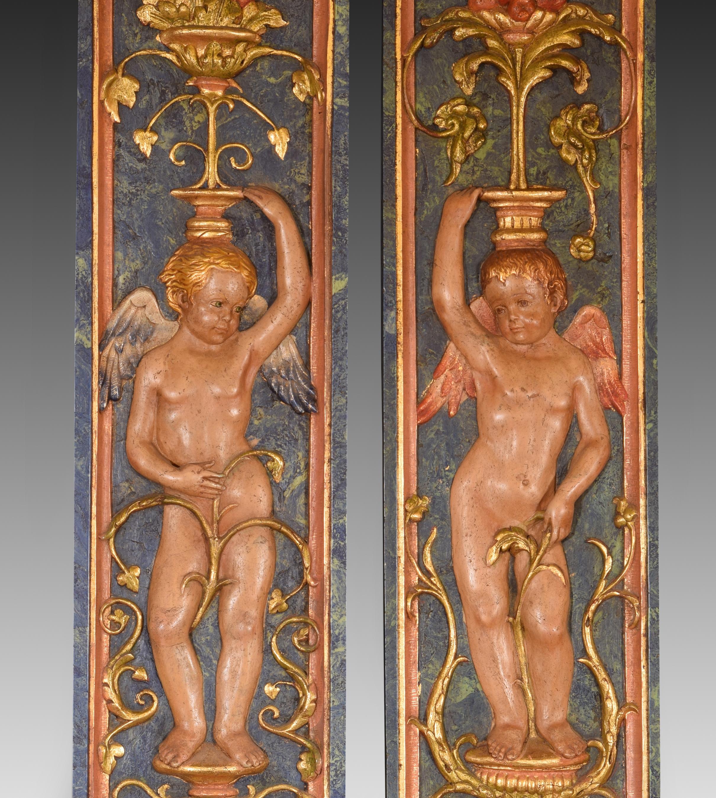 Pair of putti, relief. Molded alabaster. 20th century, following Renaissance models. 
Pair of figurative reliefs made of alabaster molded with polychrome that present two winged child figures (putti or cupids), standing, holding plant elements above