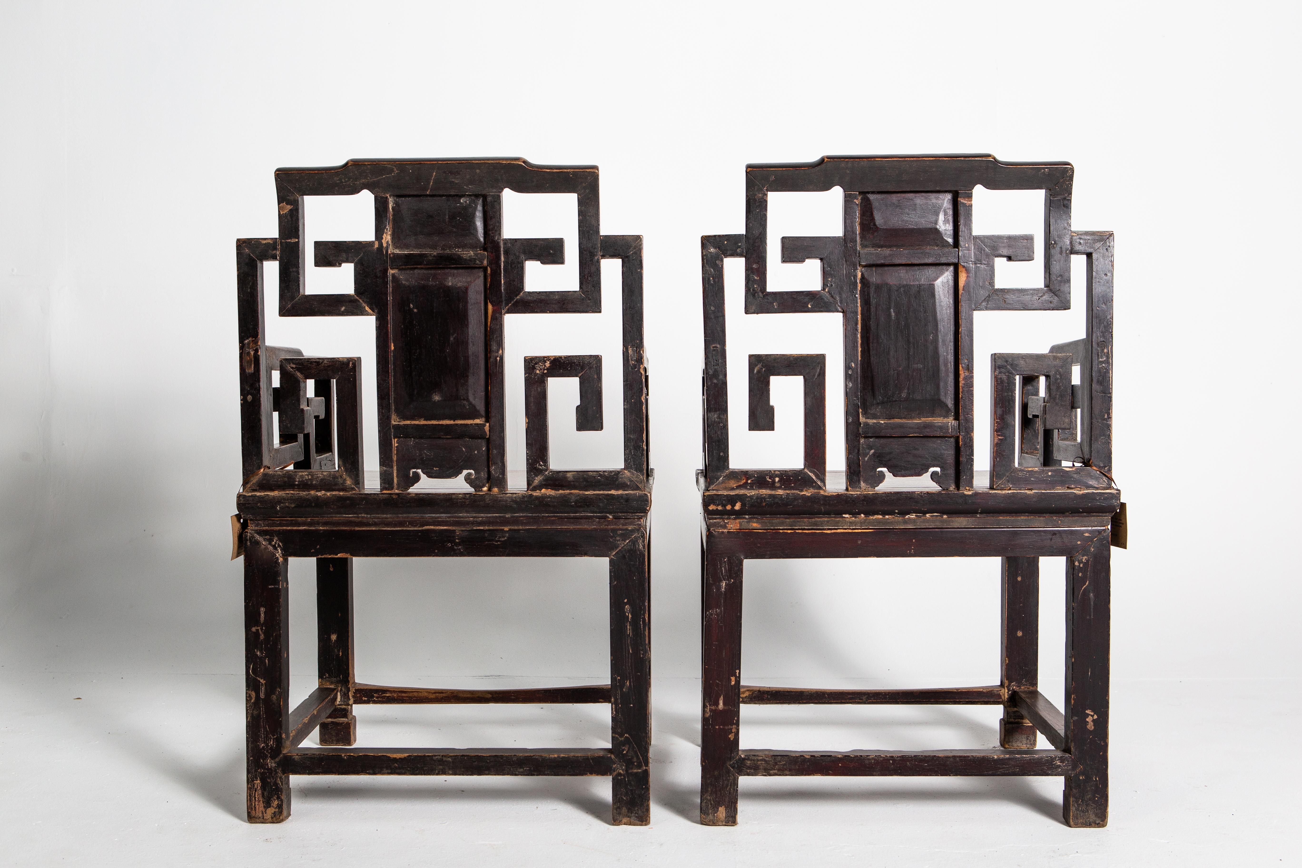 Carved from elm wood, these chairs feature an archaistic key motif and delicately carved stretchers in the form of pomegranate branches and fruit. These chairs are made in two parts: a simple high-waisted stool with scroll feet and a more decorative