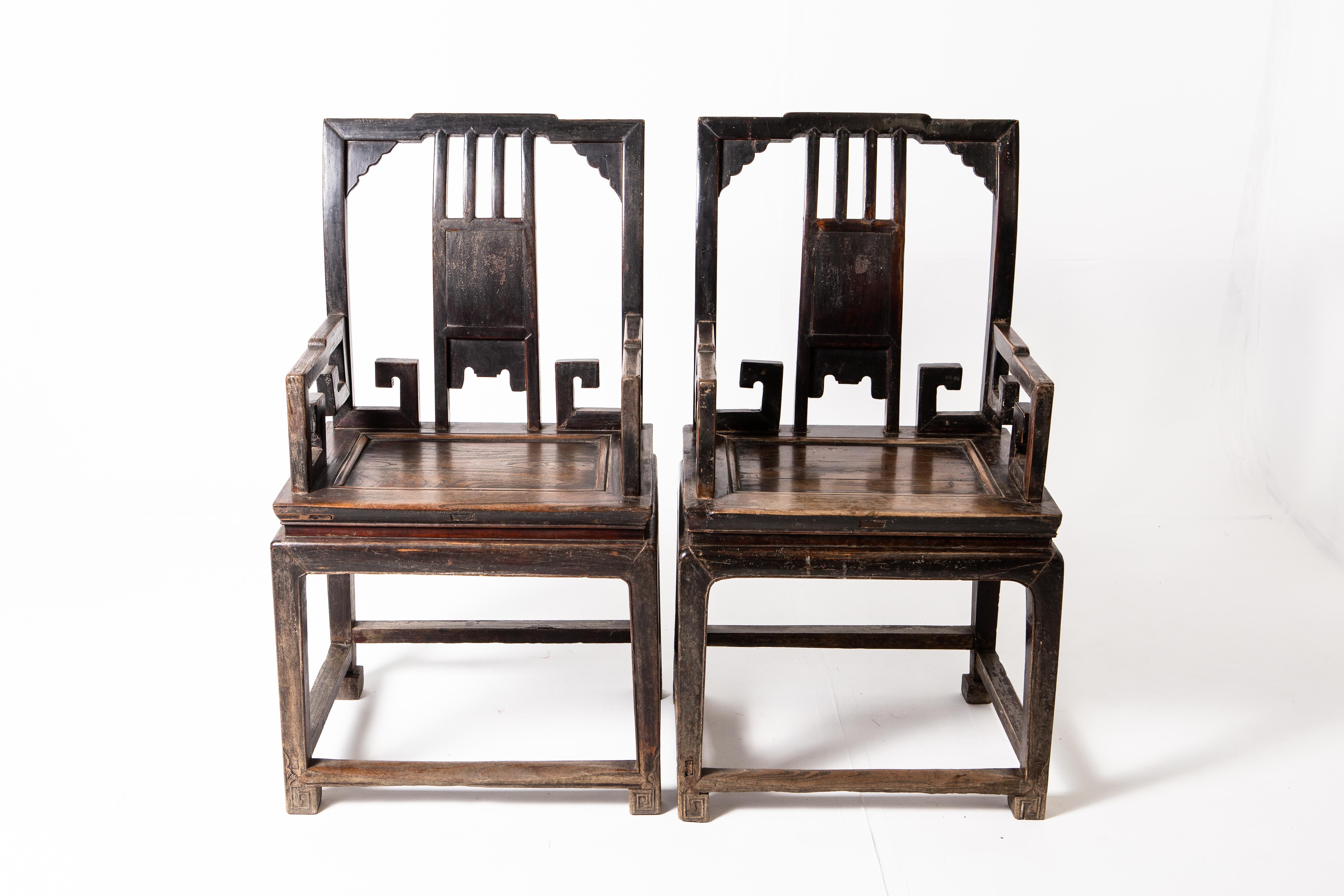 These handsome chairs are from the mid-Qing dynasty period and they feature unique scroll carvings under the armrest. The chair is made of two parts: a waisted stool and an upper backrest that resembles a screen panel. Stout and with a generous cut,