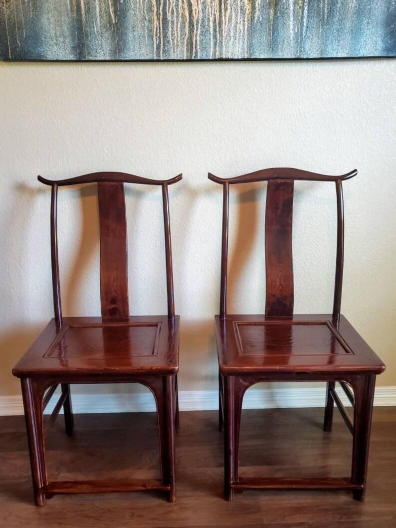 A Qing Dynasty pair of high back officials hat chairs from Shanxi, China, exquisitely handcrafted in the 19th century. Though made during the Qing Dynasty (1644 - 1912), the design of the chairs dates to the Ming Dynasty (1368 -1644). Hand carved