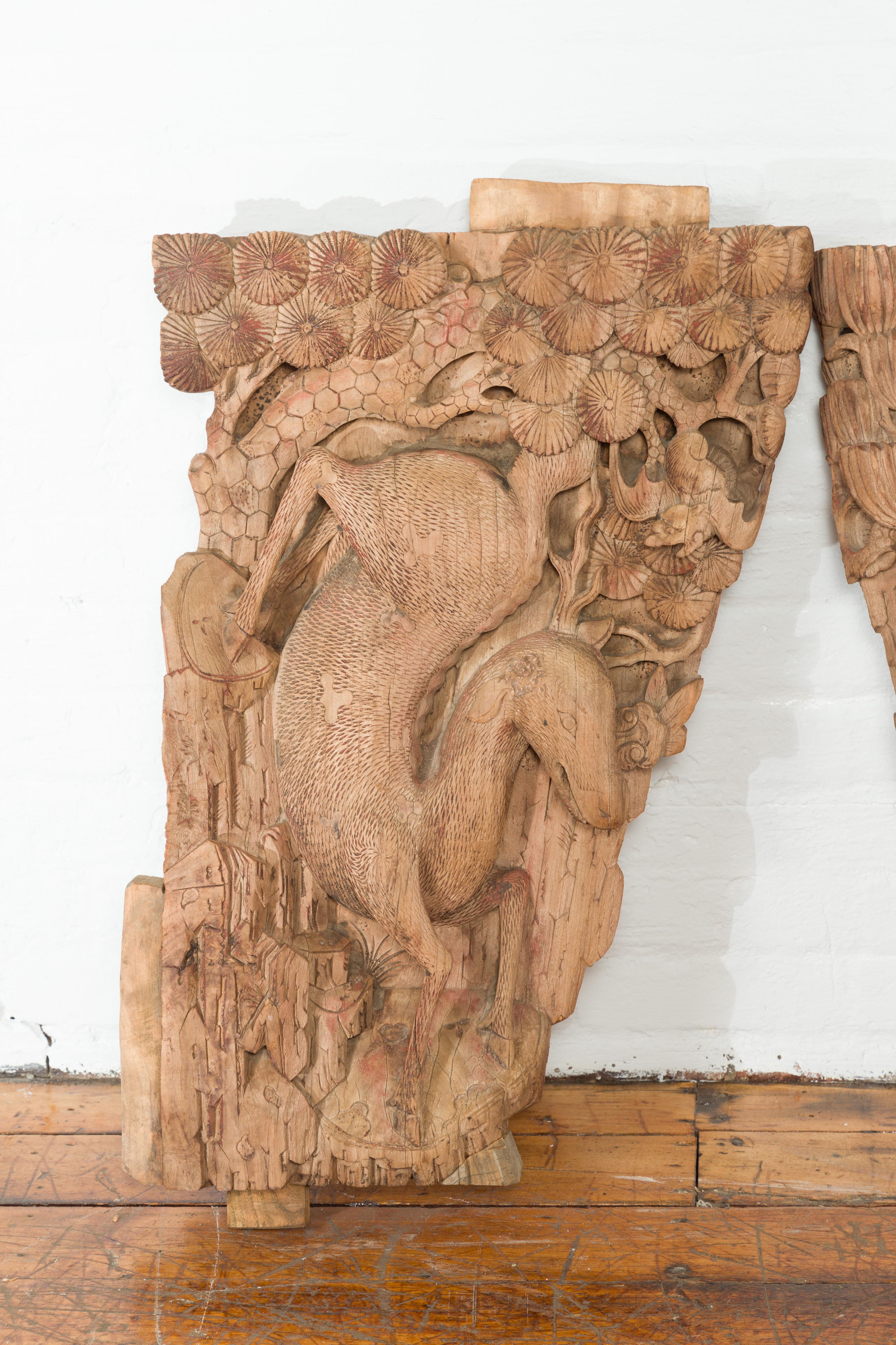 A pair of Chinese Qing Dynasty hand-carved wooden temple corbels from the 18th or 19th century with deer and their young. Originally part of a temple wall, this pair of Chinese corbels from the Qing Dynasty (or earlier), features two deer facing one