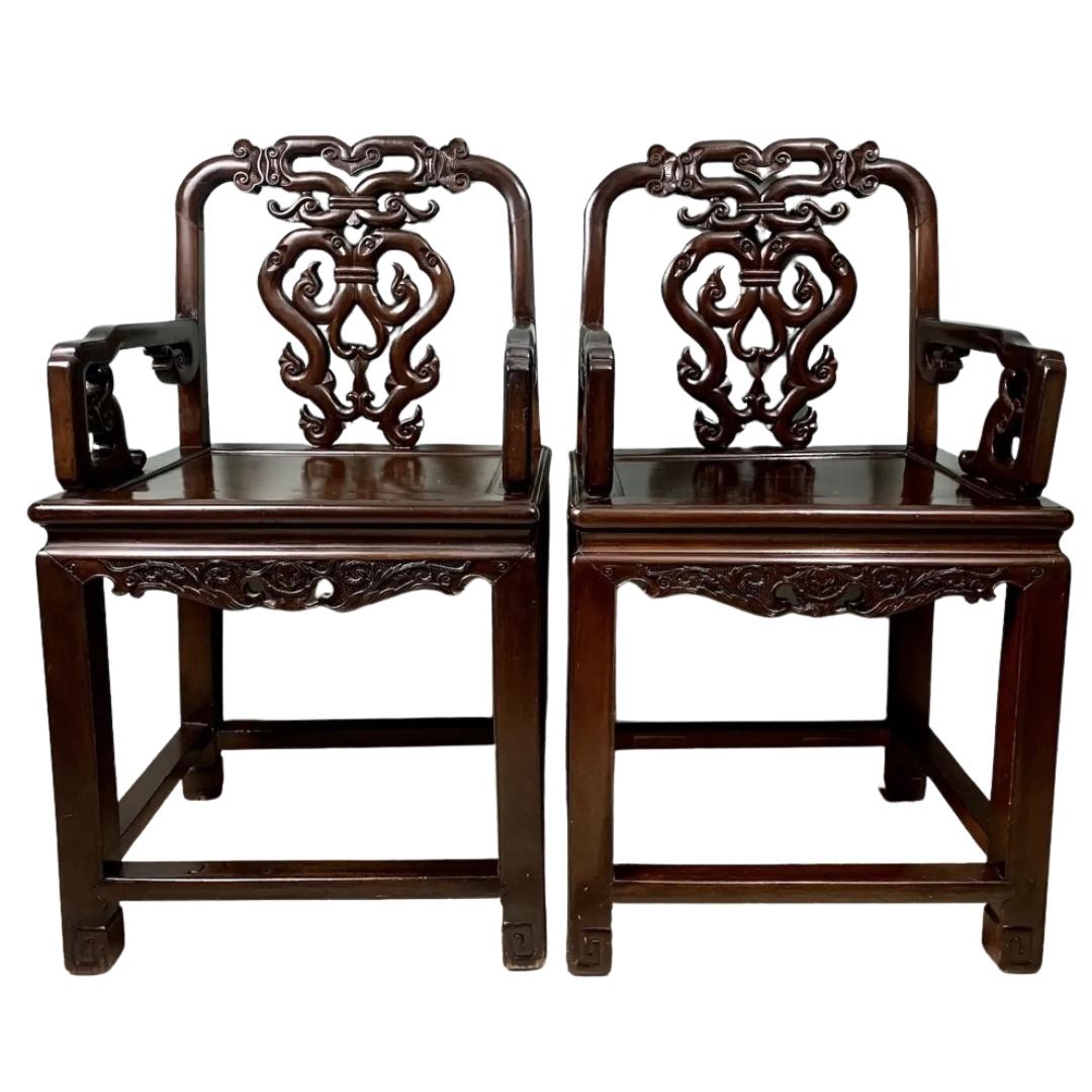 A rare, stately pair of Qing dynasty inspired rosewood scholar armchairs hand-crafted circa 1920s with traditional joinery. Ruyi motif, stylized aprons, square-sectioned legs terminating in scroll-end feet with runner. 

Displays normal wear