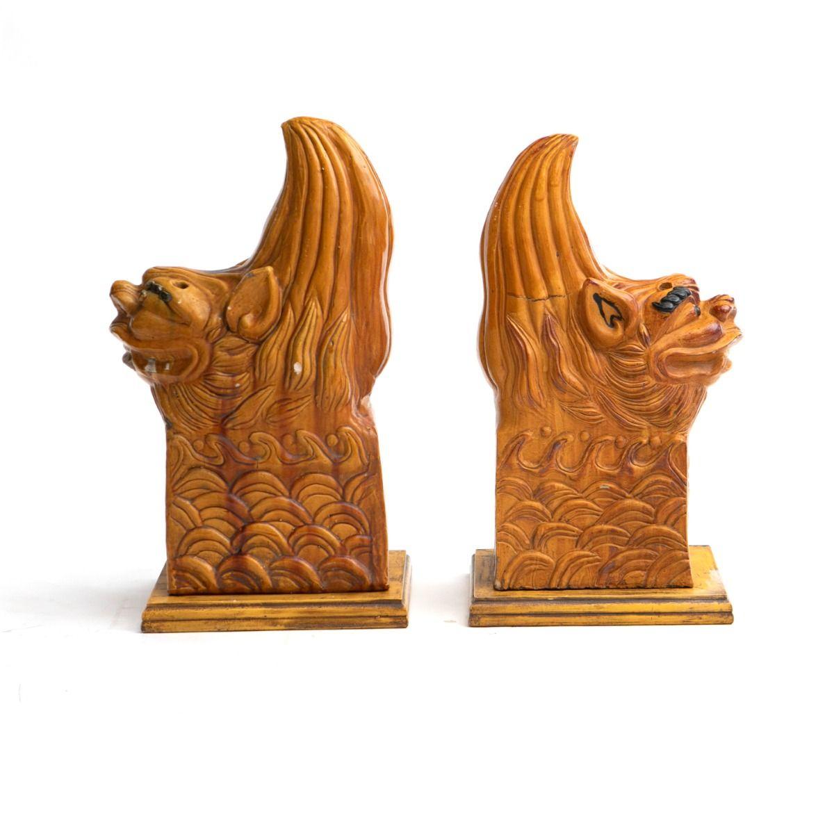 A pair of ceramic lions with yellow glaze.
Originally crafted as roof ornaments for traditional Chinese houses, dating approximately to the Qing period.

These lions rest freely on newer made wooden bases painted in matching yellow.
They remain