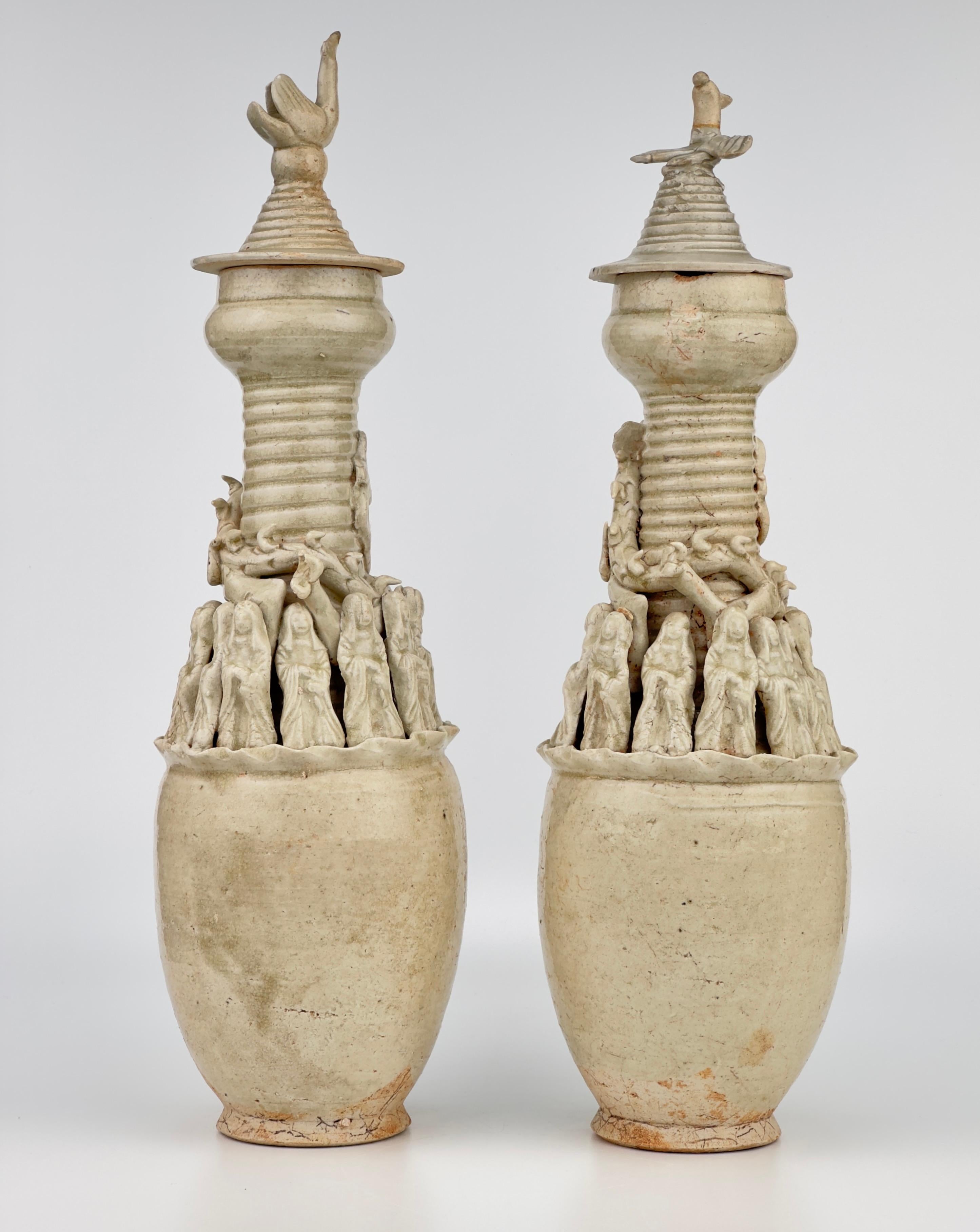 A pair of large Qingbai jars from the Song or Yuan Dynasty, designed for tomb offerings, featuring tall proportions with short bodies and extended necks. These Mingqi jars, typically created in pairs, are noted for their diverse decorations and