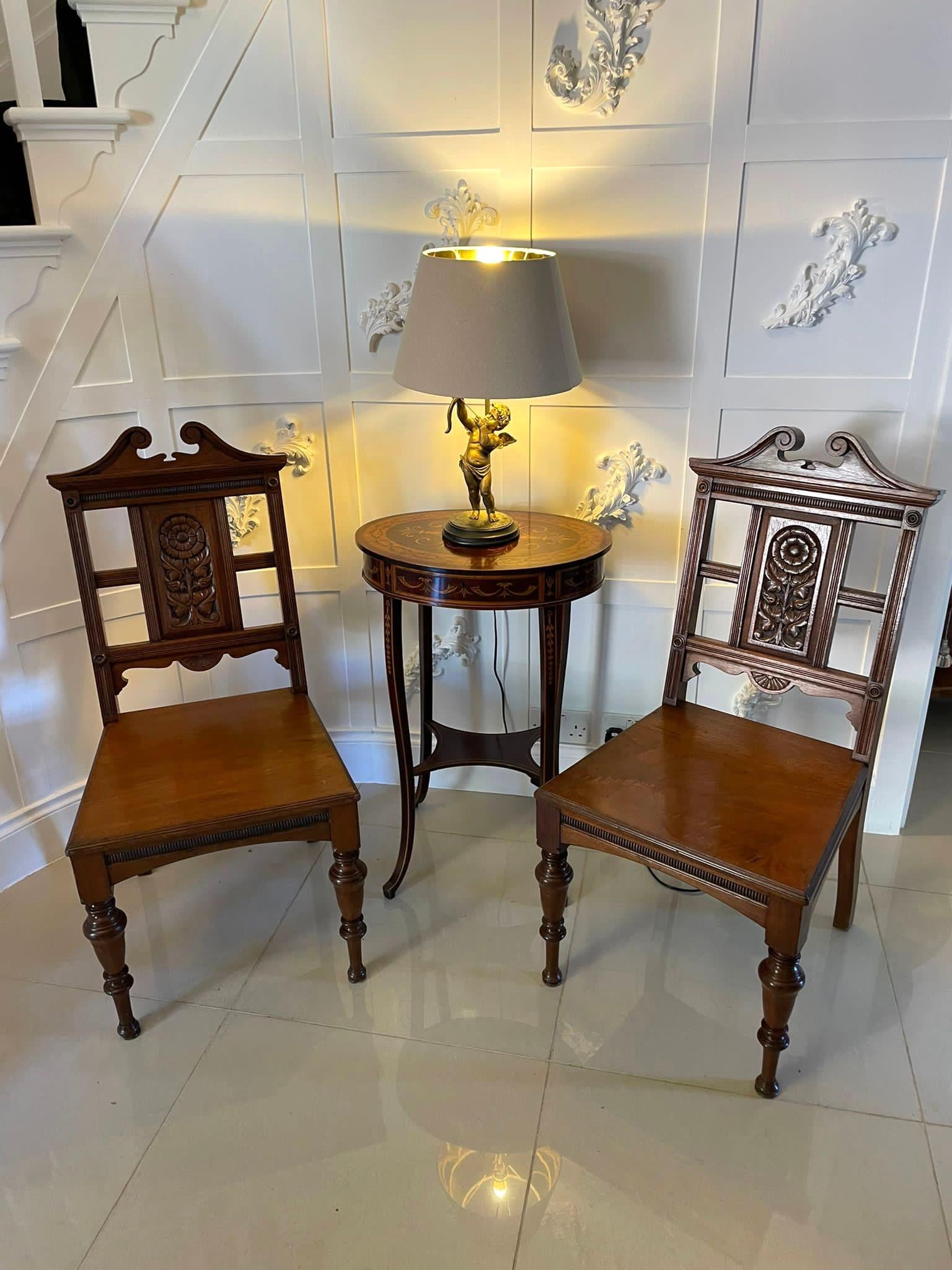 Pair of quality antique carved walnut hall chairs by Simpson and Sons, Halifax having a wonderful shaped swan neck top with a quality carved sunflower to the centre splat supported by reeded uprights. Boasting solid walnut seats, shaped reeded