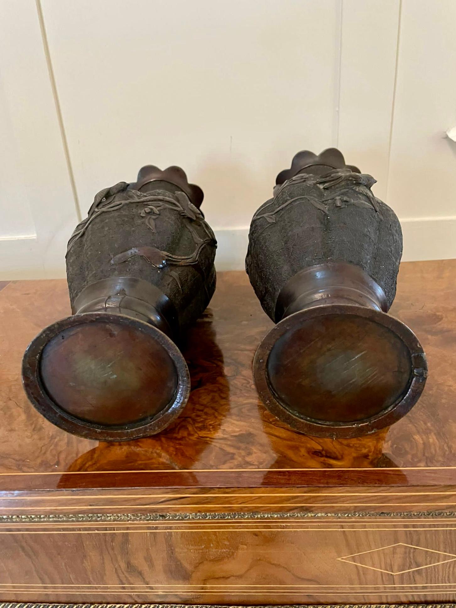 Pair of quality antique Japanese bronze vases having lovely shaped tops and elephant head handles with shaped fluted vases. They are both applied with birds, trees and flower decorations on a round base. They are of the Meiji period.

A Delightful