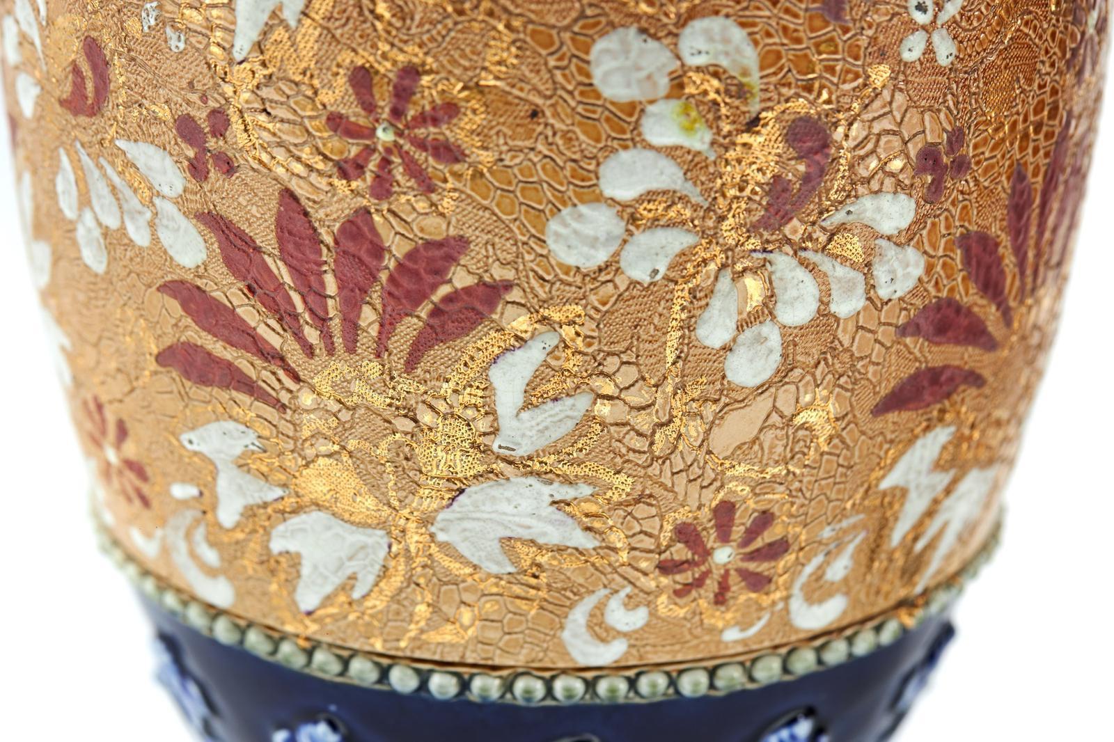 Coppia di vasi antichi di qualità di Royal Doulton con graziose decorazioni dipinte a mano in blu e verde sulla parte superiore e inferiore del vaso e decorazioni dipinte a mano in oro, rosso e bianco al centro su una base circolare.