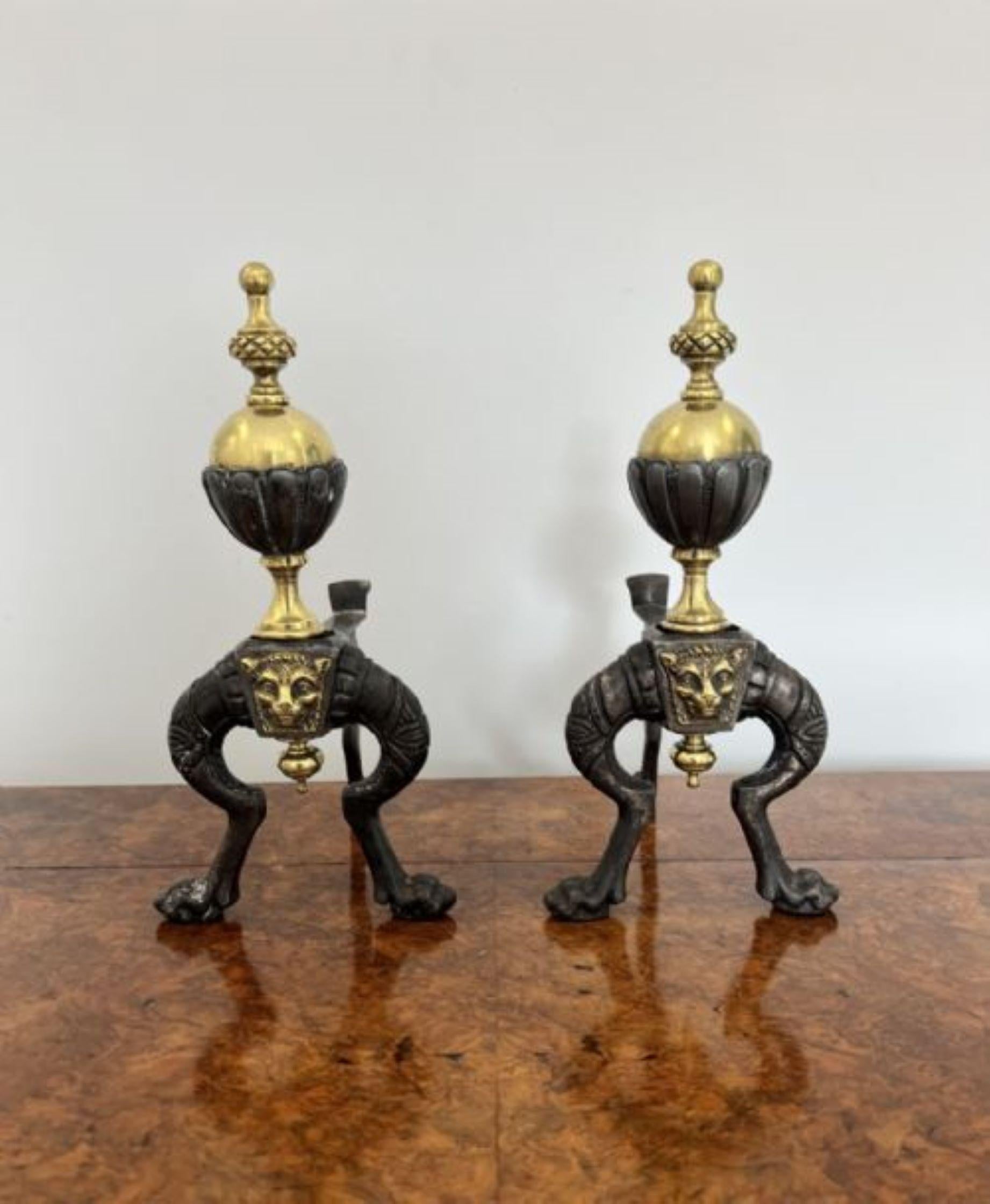 Pair of quality antique Victorian brass and iron fire dogs having a quality pair of brass and iron fire dogs with turned finials above a brass ball, brass lions heads to the shaped iron stands with claw feet. 