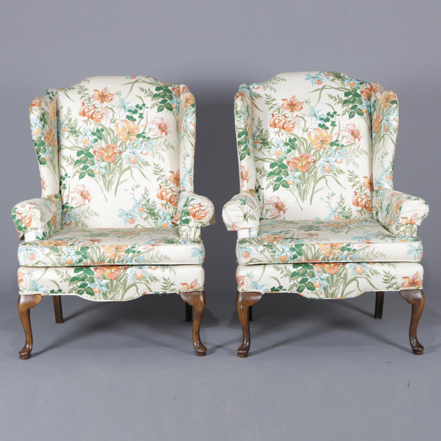 Pair of Queen Anne style fireside wingback chairs feature floral tiger lily print upholstery, circa 1930.

Measures: 44