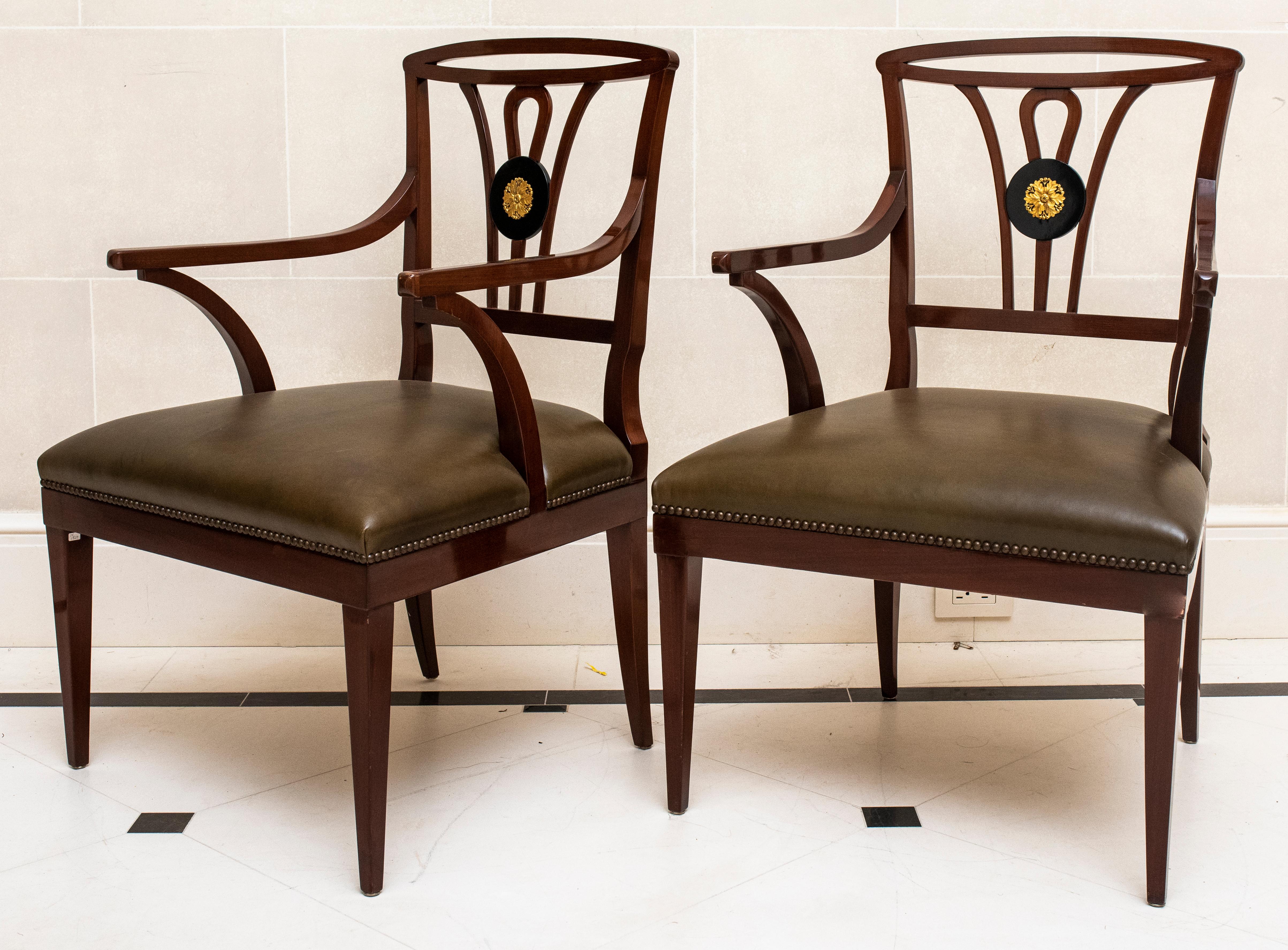 Queen Anne Revival pair of carved wood armchairs with leather upholstered seat and ebonized round medallion back insert with ormolu rosette. 

Dealer: S138XX
