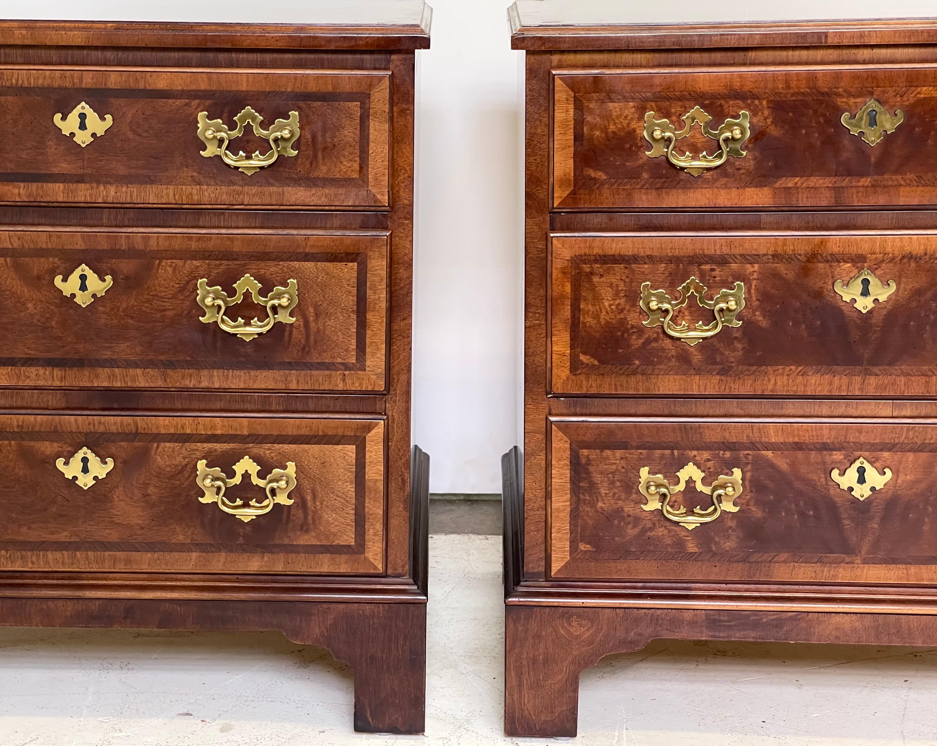 Pair of 20th century burl walnut end tables or nightstands made by Henredon in the style of Queen Anne. Each case holds three drawers with brass back plates, bail handles, and escutcheons. They are raised on bracketed feet.