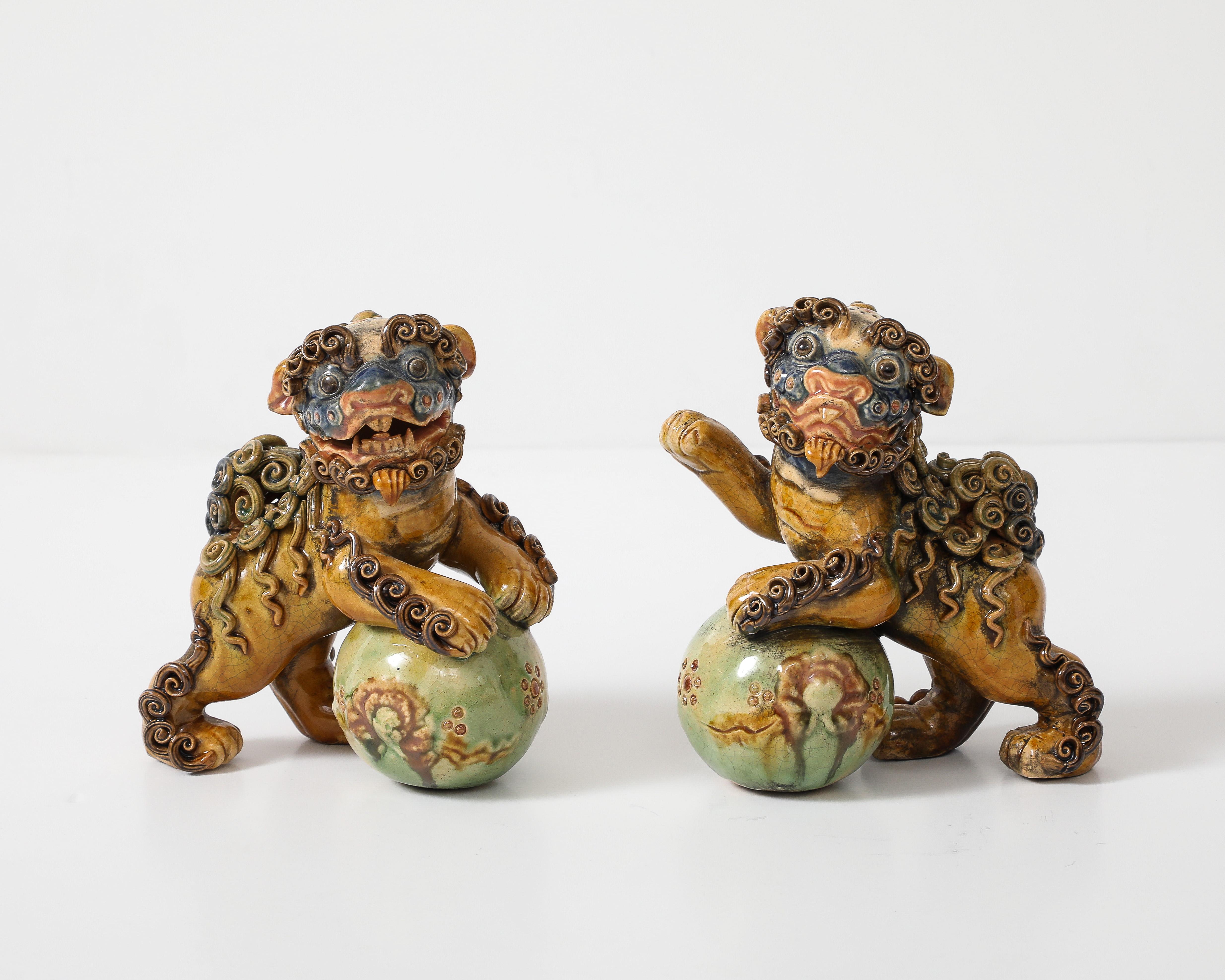 Coppia di incantevoli Foo Dog in ceramica policroma  / Leoni in stile Qing. Dettagli fantastici e una bellissima combinazione di colori ocra, verde, marrone e blu. I cani Foo sono statue simboliche e protettive e sono progettati in coppia: uno è