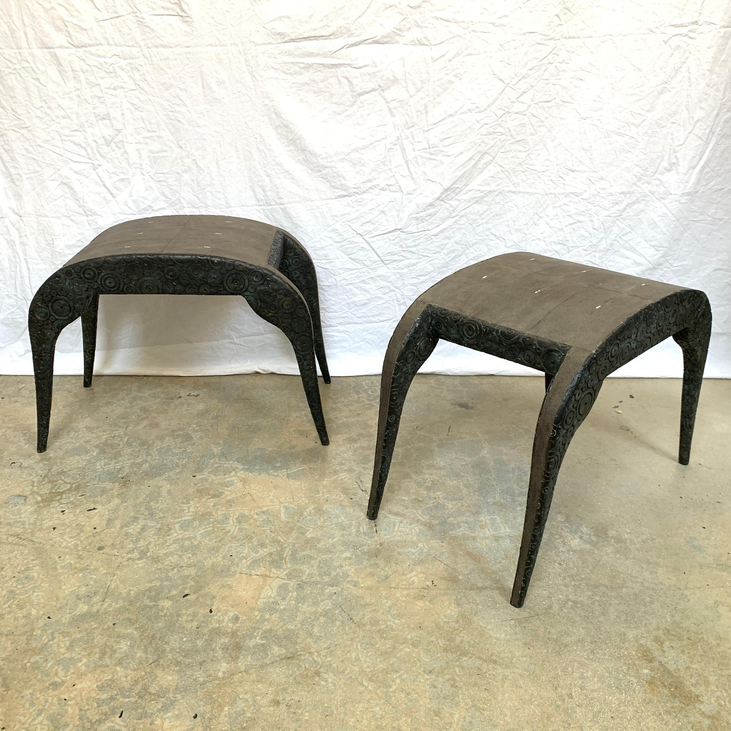 Stunning pair of heavy sculptural stools rendered in a frame of bronze-patina brass with sculpted circles/rings topped with antique black shagreen seat and leg spine, designed by Ria & Yiouri Augousti, Paris, France, 1990.