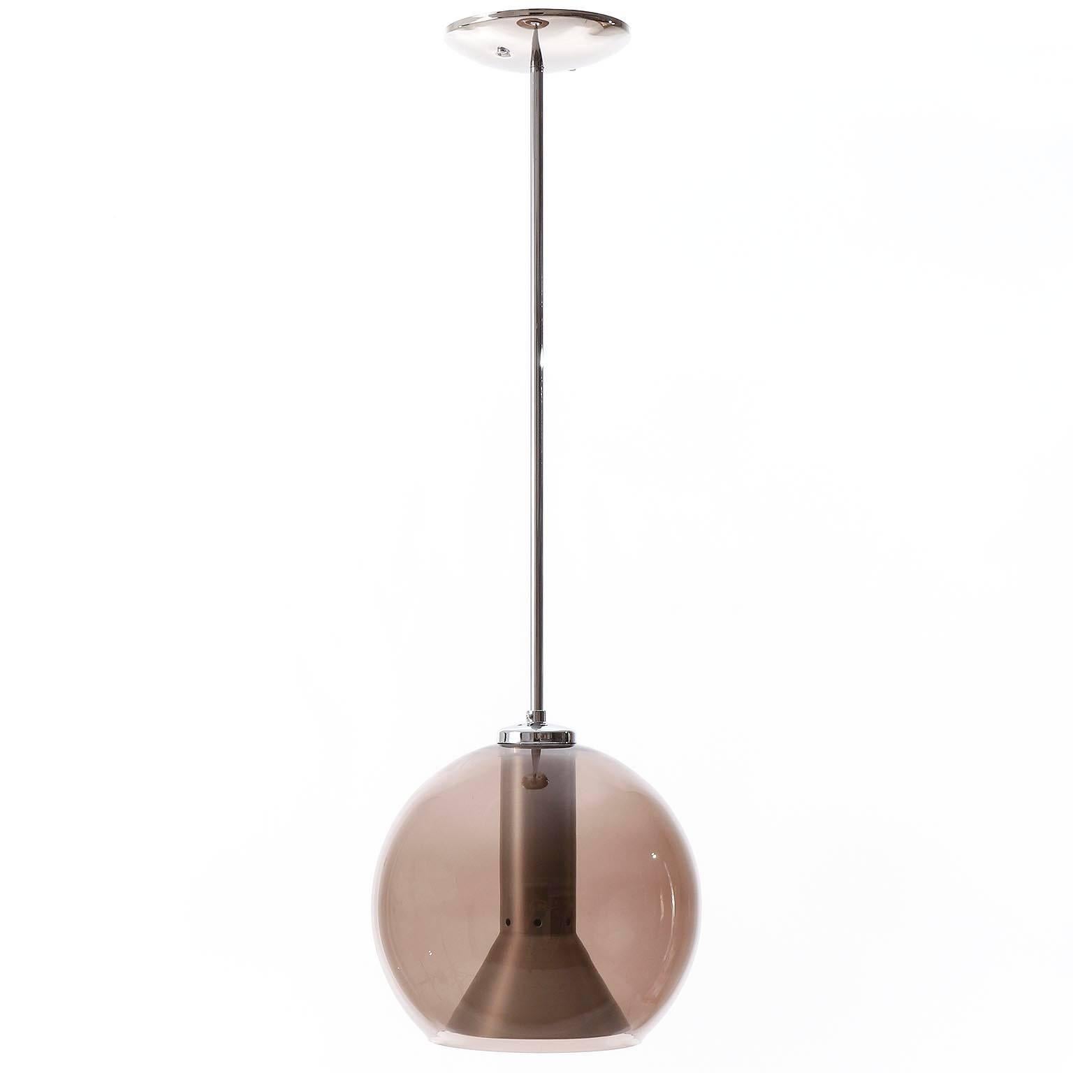 A pair of pendant lights or hanging lamps by Frank Ligtelijn for RAAK Amsterdam, Netherlands, manufactured in midcentury, circa 1960.
Each light features a smoked glass globe with an aluminium reflector inside. The globe is made of quality glass