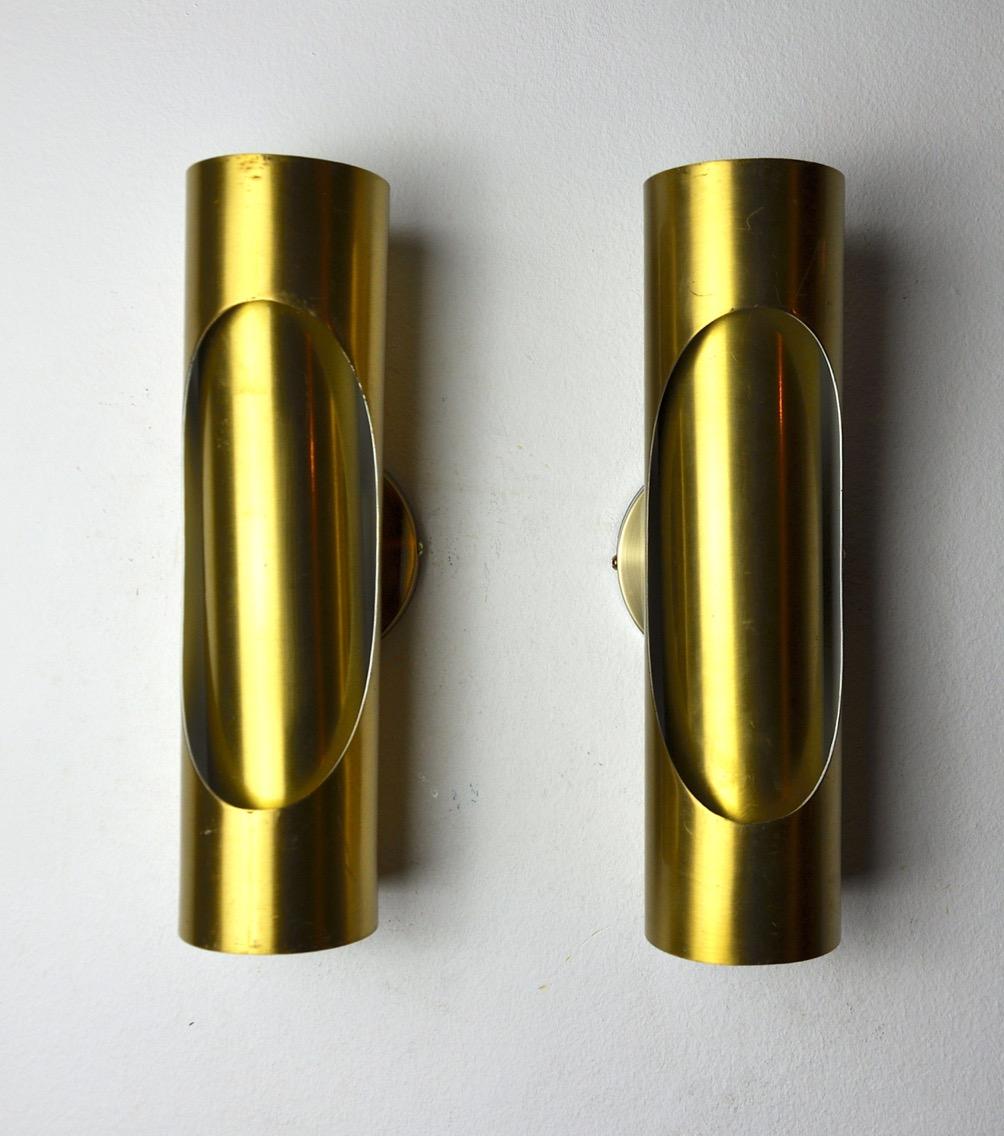 Very nice pair of raak tubular wall lights designed and produced in the 1970s. Tubular golden brass structure composed of 2 light points. Unique objects that will illuminate marvelously and bring a real design touch to your interior. Electricity