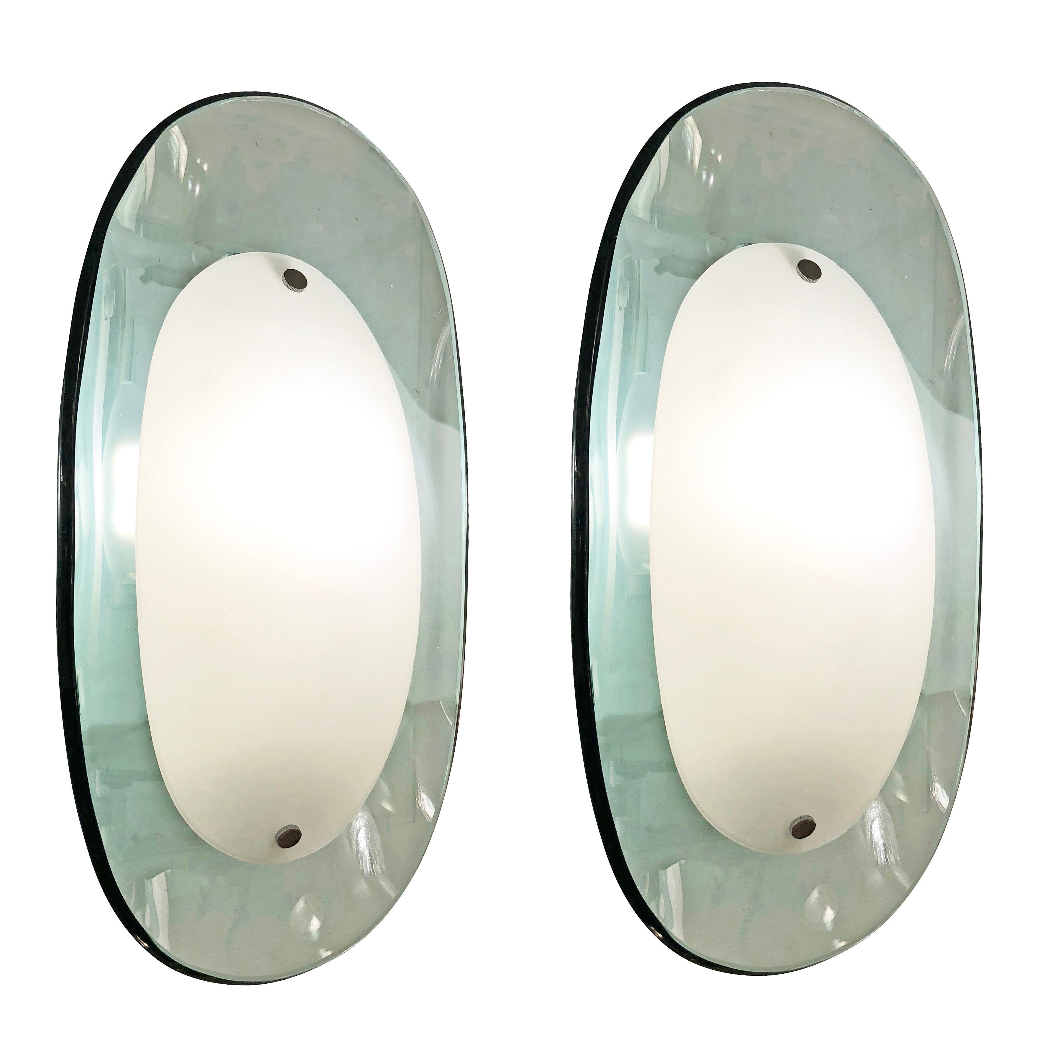 Pair of elegant midcentury wall lights by Cristal Art each featuring two racetrack glasses; a light blue concave one on the back and white frosted convex one on the front. Hardware is nickel and lacquered white. Each holds one candelabra