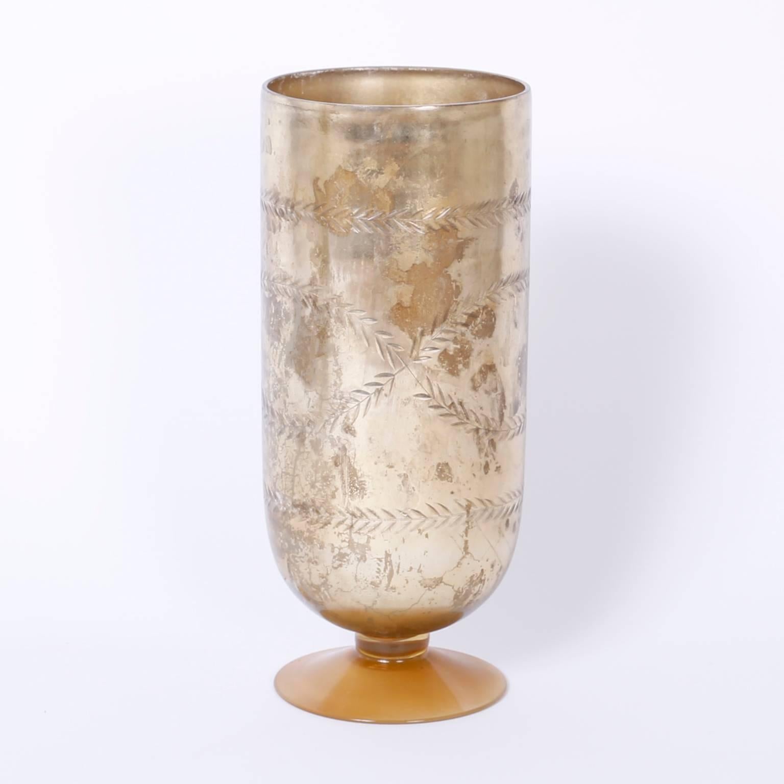 Pair of glass vessels or vases with a classic footed form, etched
laurel leaves and a contrived oxidation that conveys an intimate
warmth.