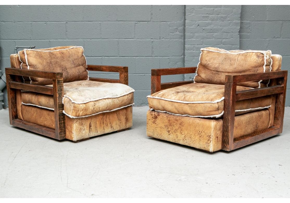 Rarely seen and extraordinary pair of Ralph Lauren rustic oak frame club chairs in sheep skin upholstery. With square hewn oak wood frames in a distressed black on brown finish. The open sides with slat supports. The frames upholstered in natural