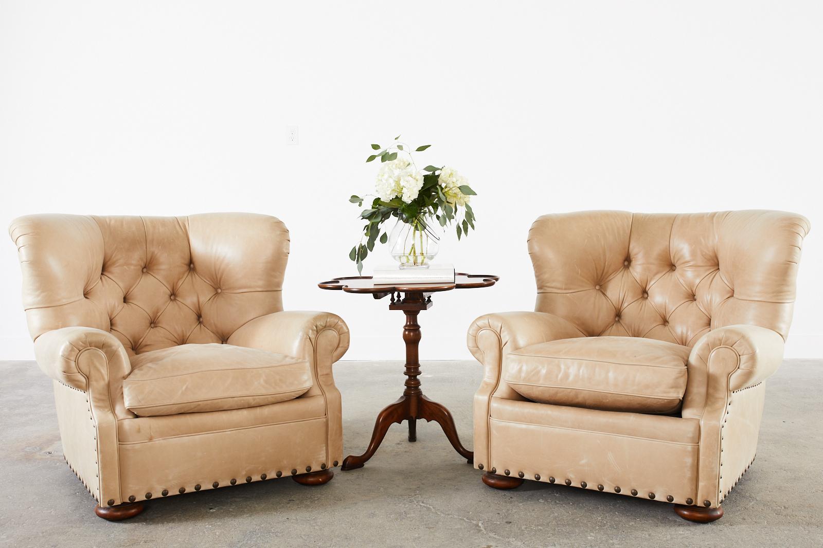 Fabulous bespoke pair of tufted leather wingback club, lounge, or armchairs by Ralph Lauren. The armchairs feature a hardwood frame covered in a custom warm light beige sand toned leather accented with large patinized brass tack nail heads. The deep