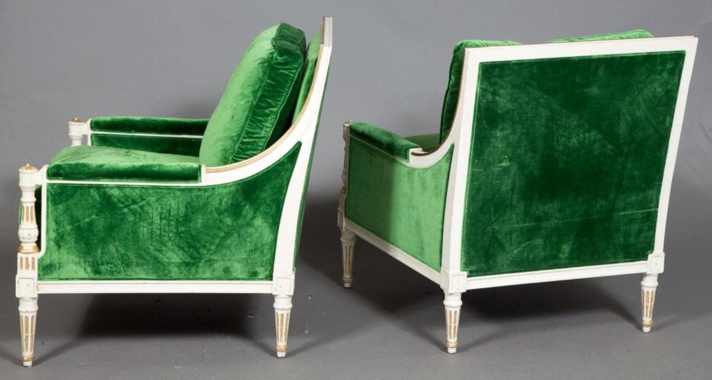 Pair of Ralph Lauren Louis XVI style green velvet upholstered painted bergere chairs. Parcel paint and gilt decorated in a slightly distressed finish. Each with two overstuffed cushions. Both bearing the Ralph Lauren Label.